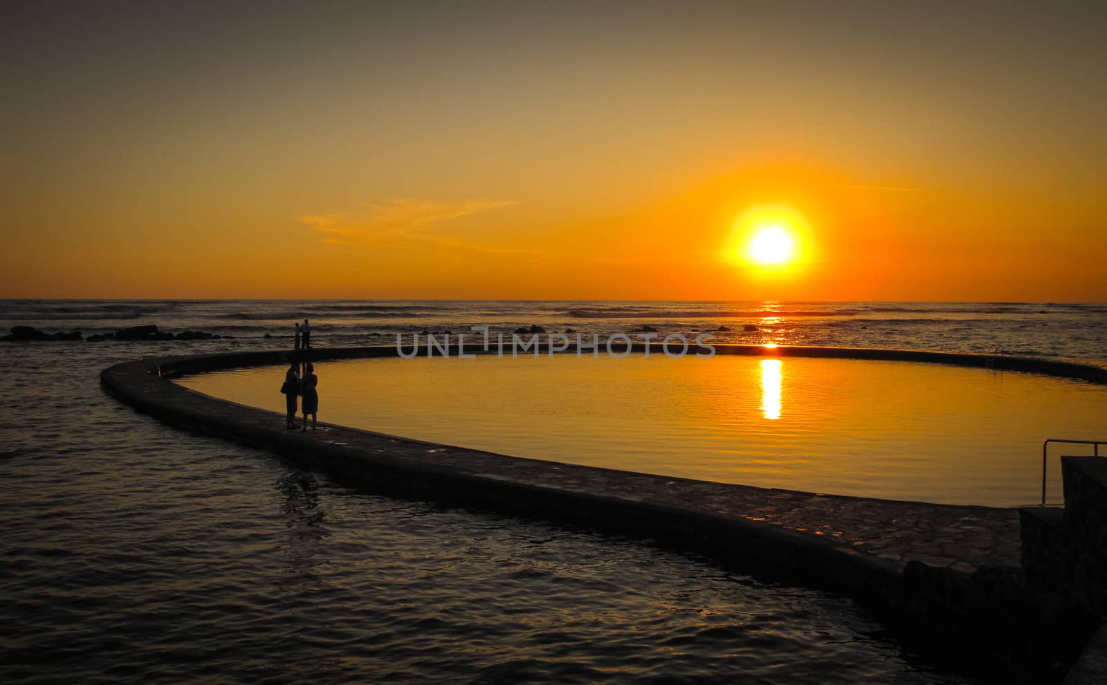 Sun goes down on a beach and salt water pool at a resort in El Salvador, Central America.