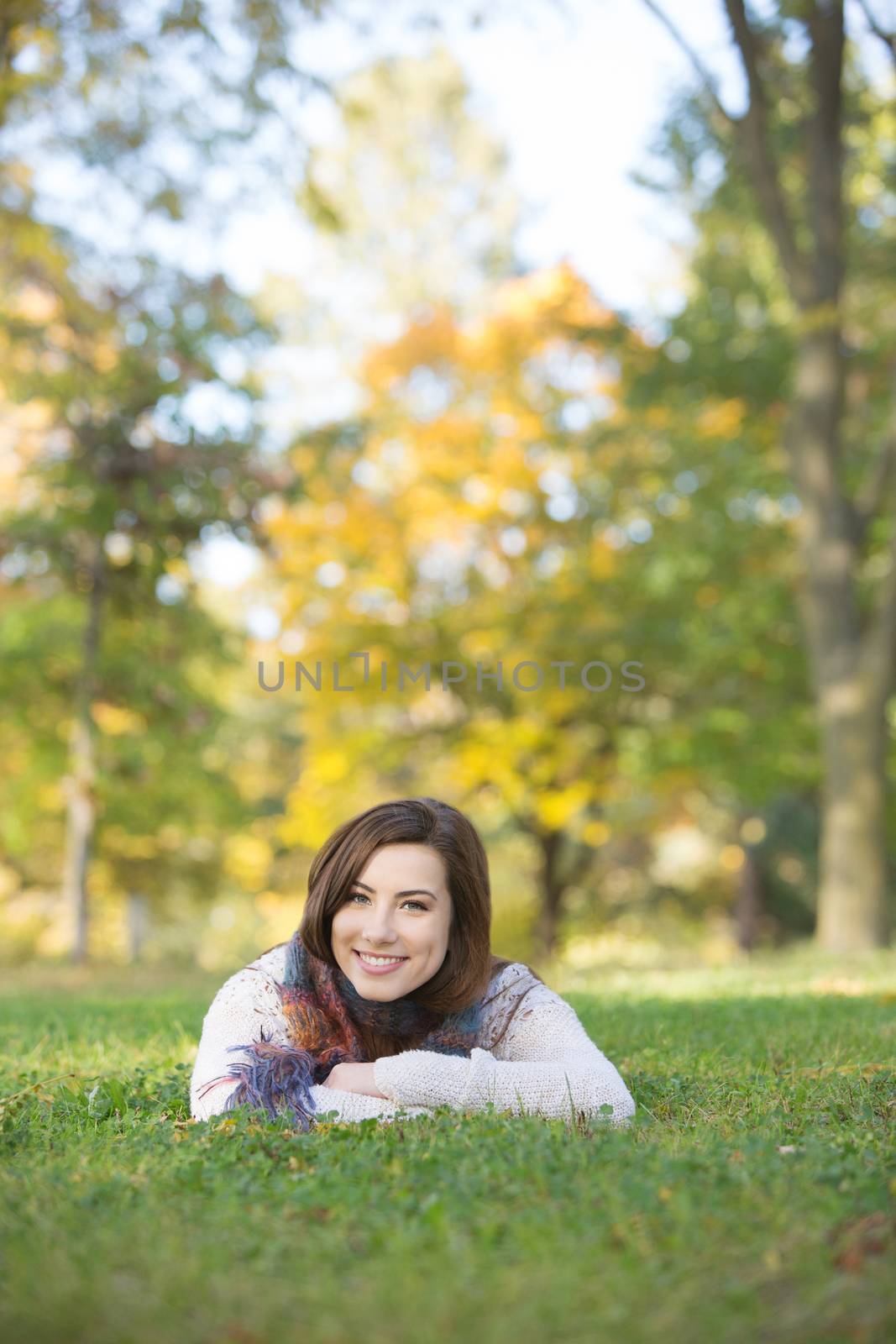Happy Caucasian teen girl laying down outdoors