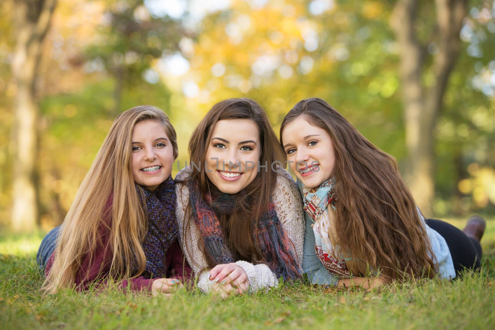 Three happy Caucasian teen girls sitting together