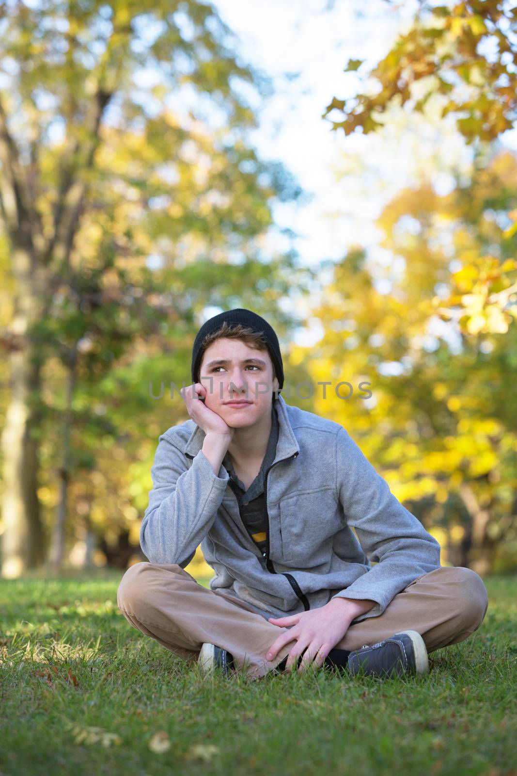 Serious male teenager sitting and looking over