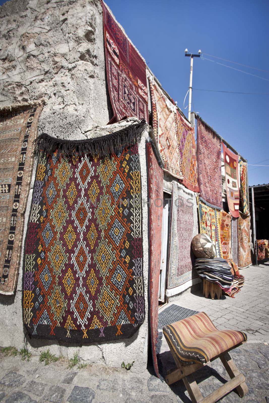 Vendor selling Turkish rugs in an outdoor bazaar