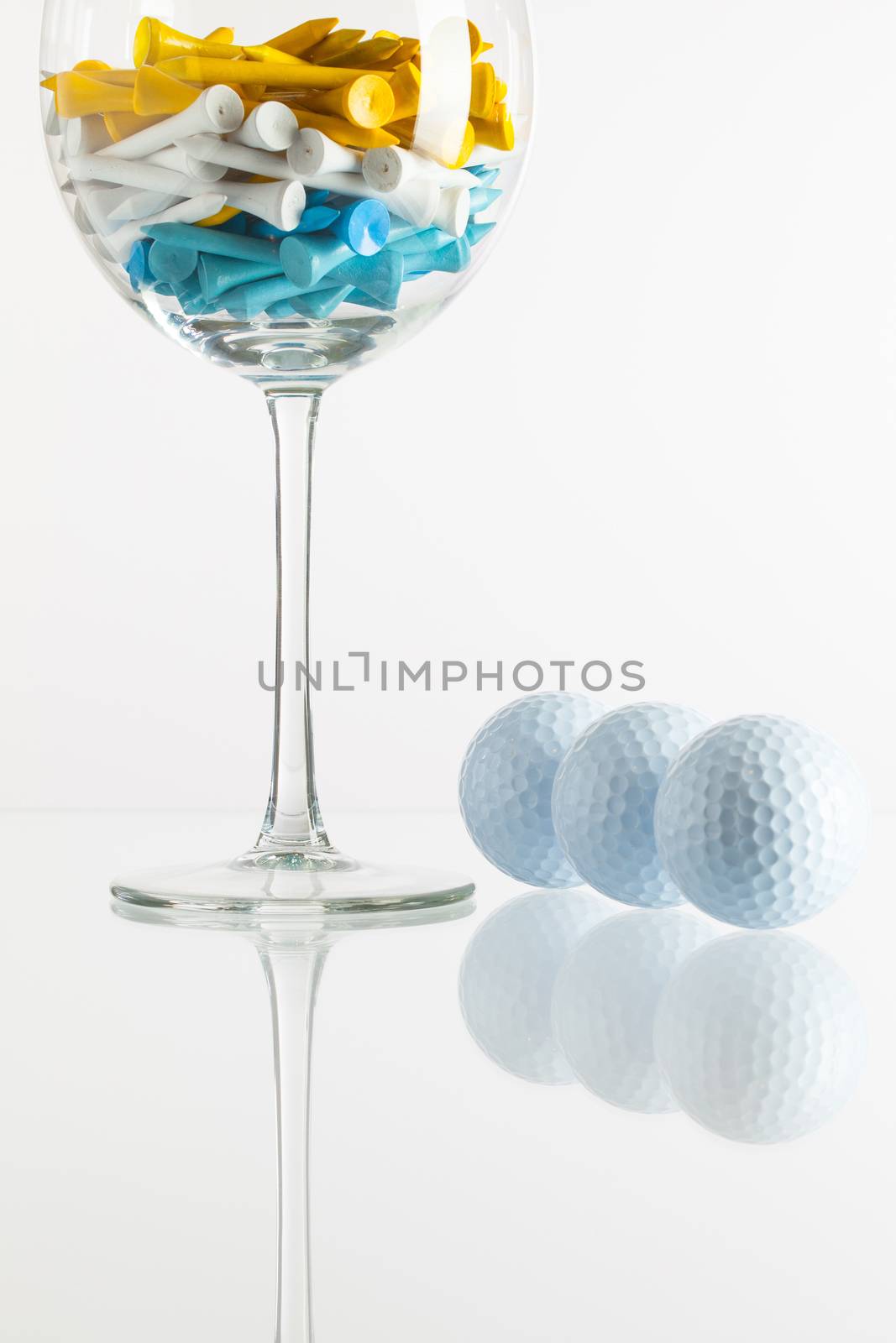 Glass of wine and golf equipments by CaptureLight