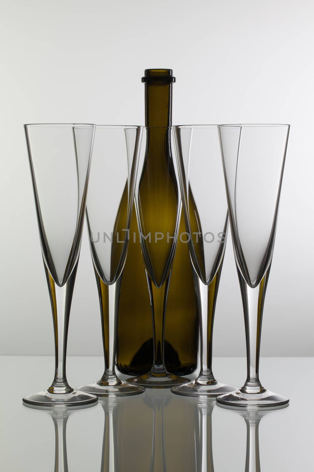 Empty champagne glasses on the glass table by CaptureLight