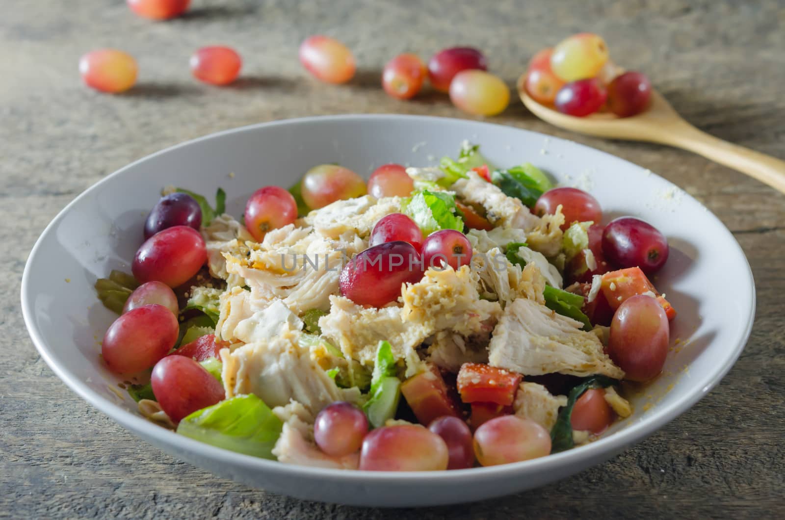 Mix salad with grapes and chicken on white dish