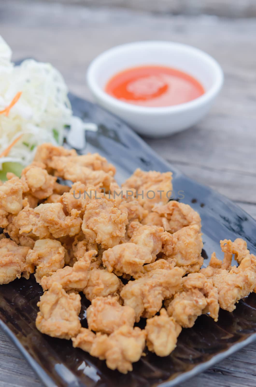 deep fried chicken tendons with fresh vegetable and chili sauce, asian style cuisine