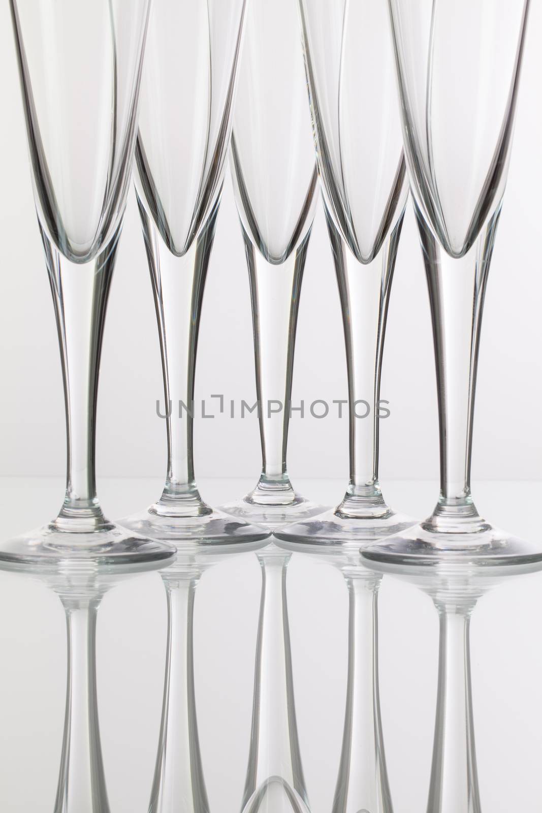Five champagne glasses on a glass plate
