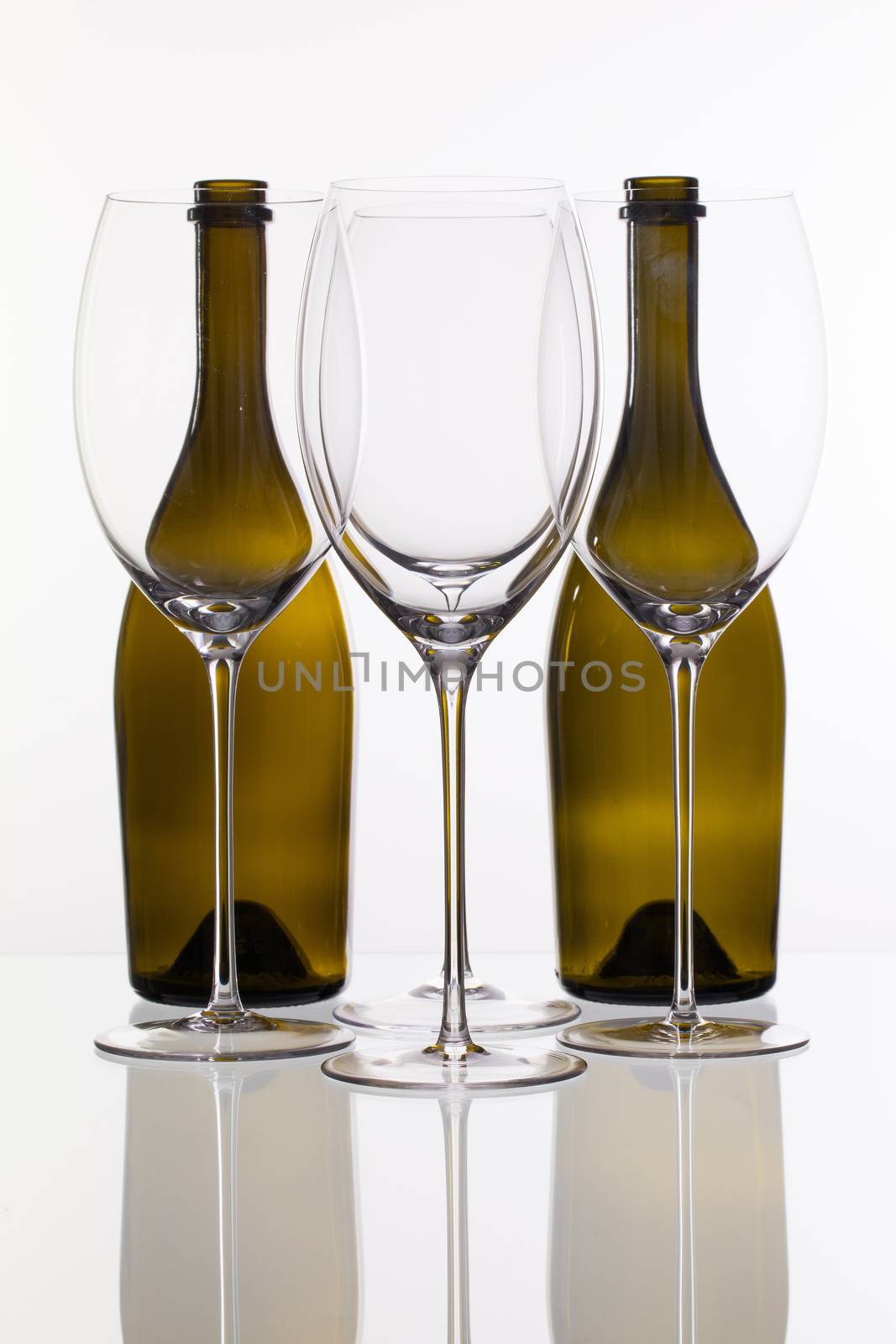 Four wine glasses and two bottle on a glass plate