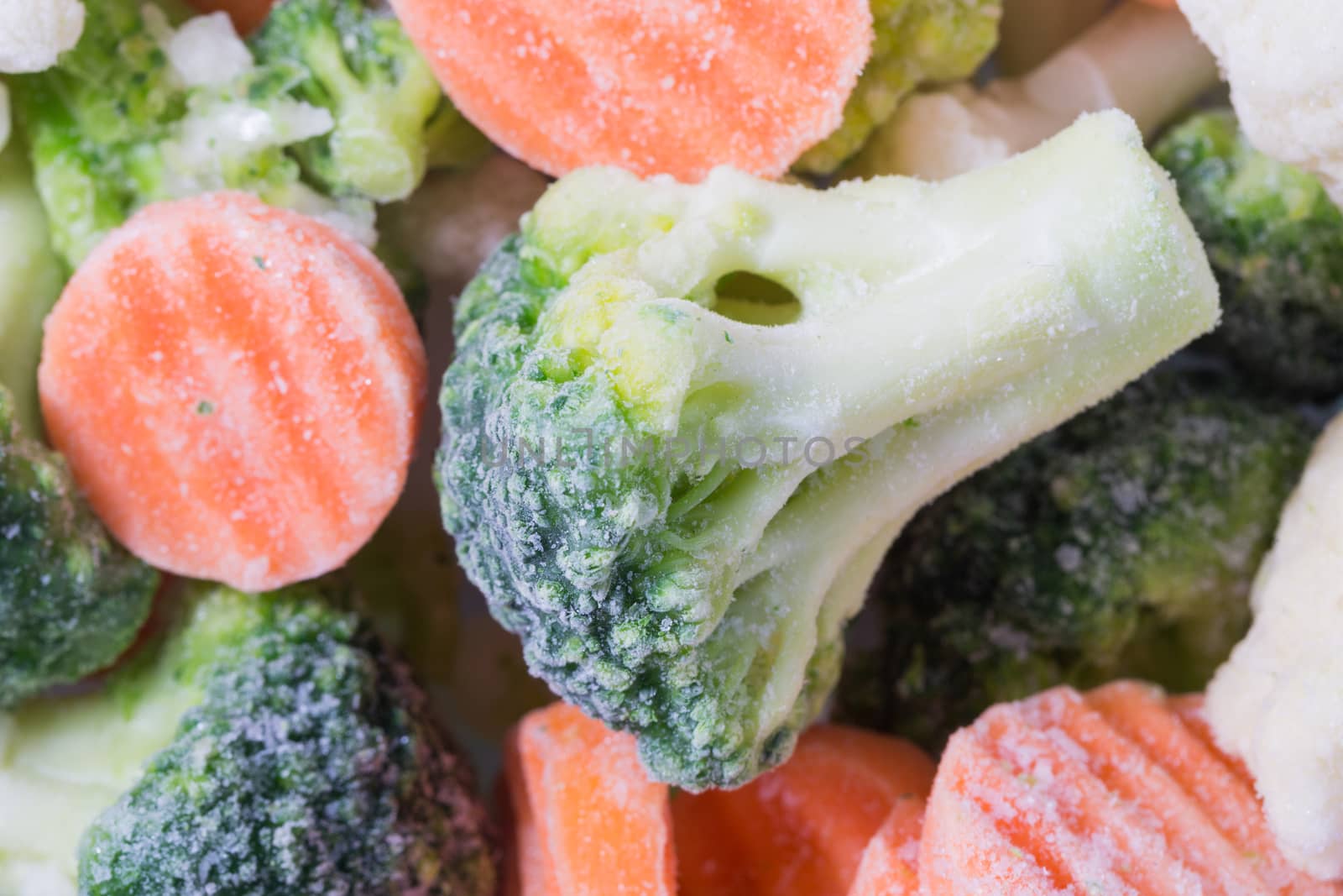 Picture of a bunch of frozen vegetables with focus on a piece of broccoli