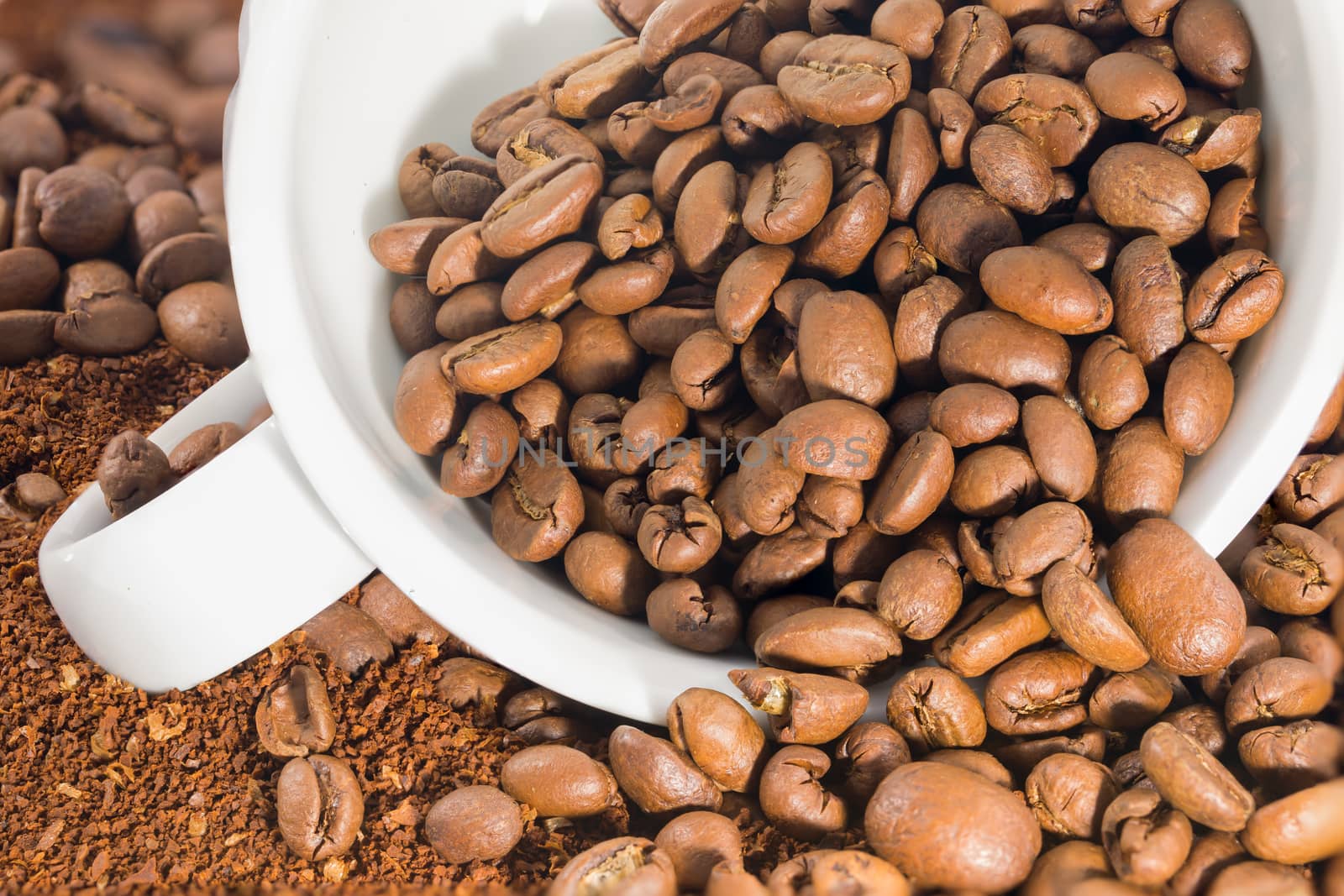 white cup with coffee beans by Stootsy