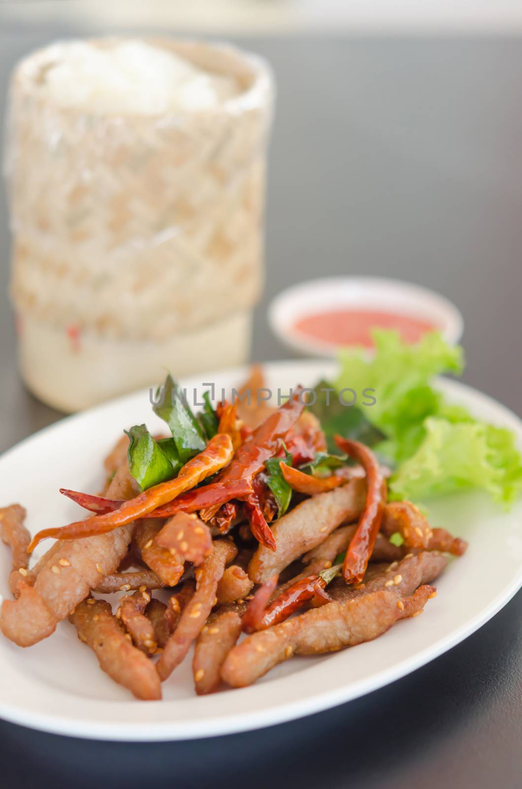 Closeup of fresh fried meat with sesame and chili