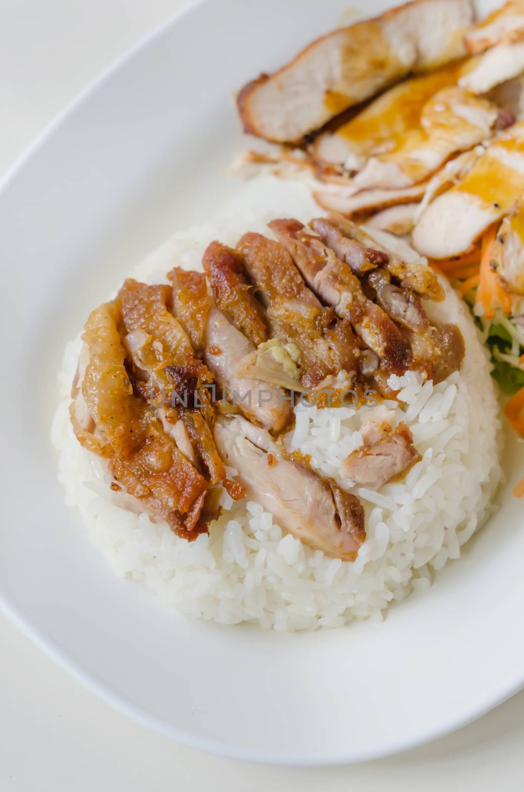 close up fried Chicken over steamed rice on plate