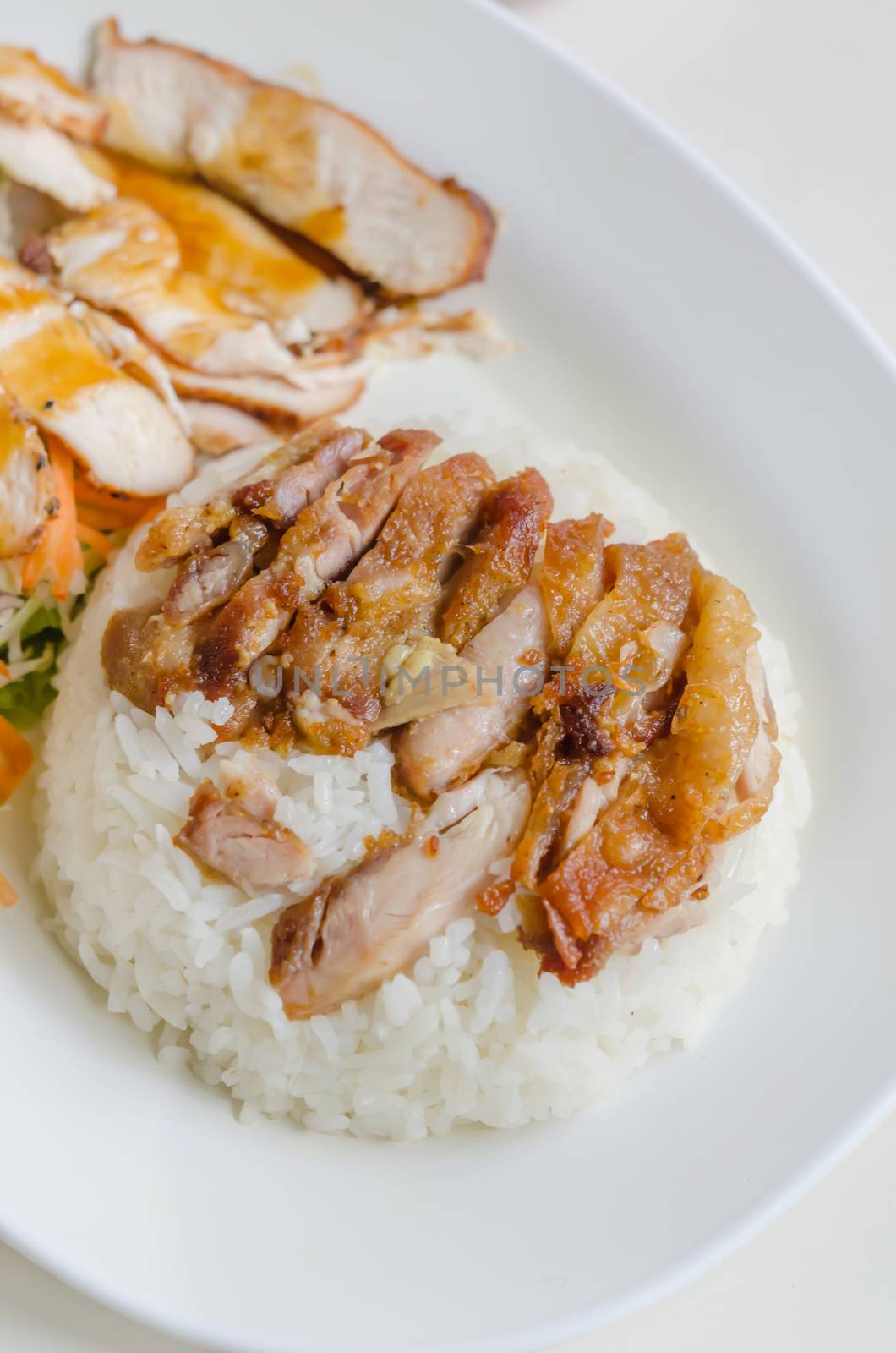 close up fried Chicken over steamed rice on plate