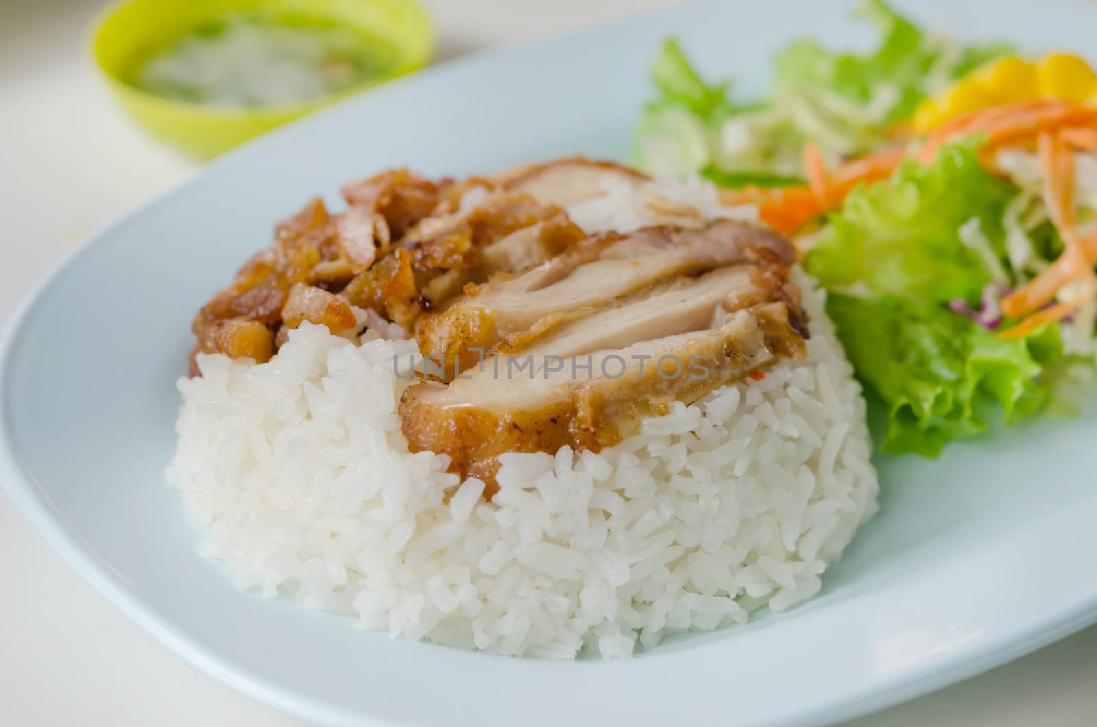 close up fried Chicken over steamed rice on plate