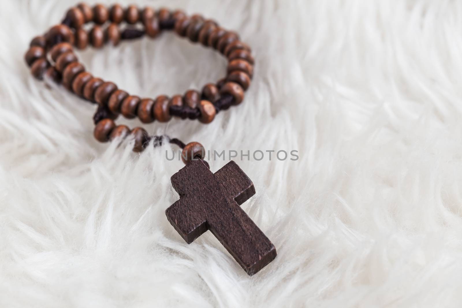 Christian cross necklace on sheep wool, Jesus religion concept as good friday or easter festival