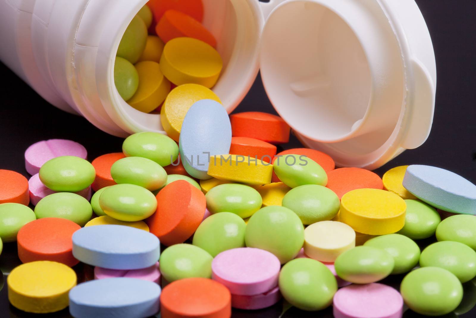 lot of colorful pills with white box on black background