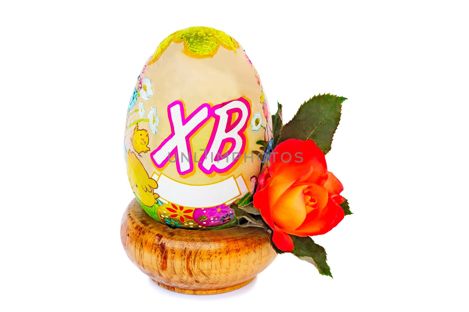 Beautiful Easter egg on a wooden stand and a flower red roses. Presented on a white background..