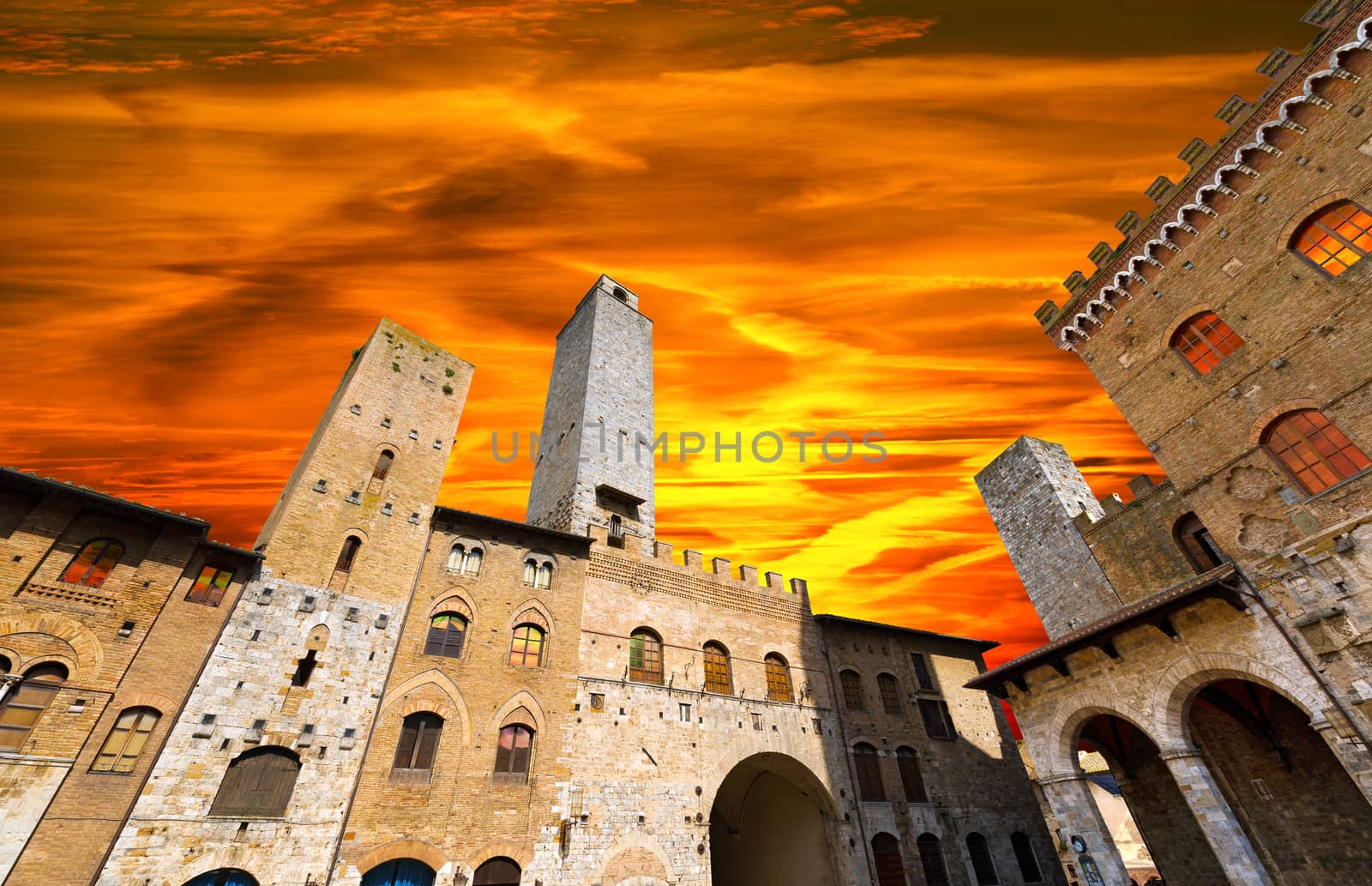 Buildings and towers in Piazza del Duomo at sunset, San Gimignano medieval town (UNESCO heritage), Siena, Tuscany, Italy