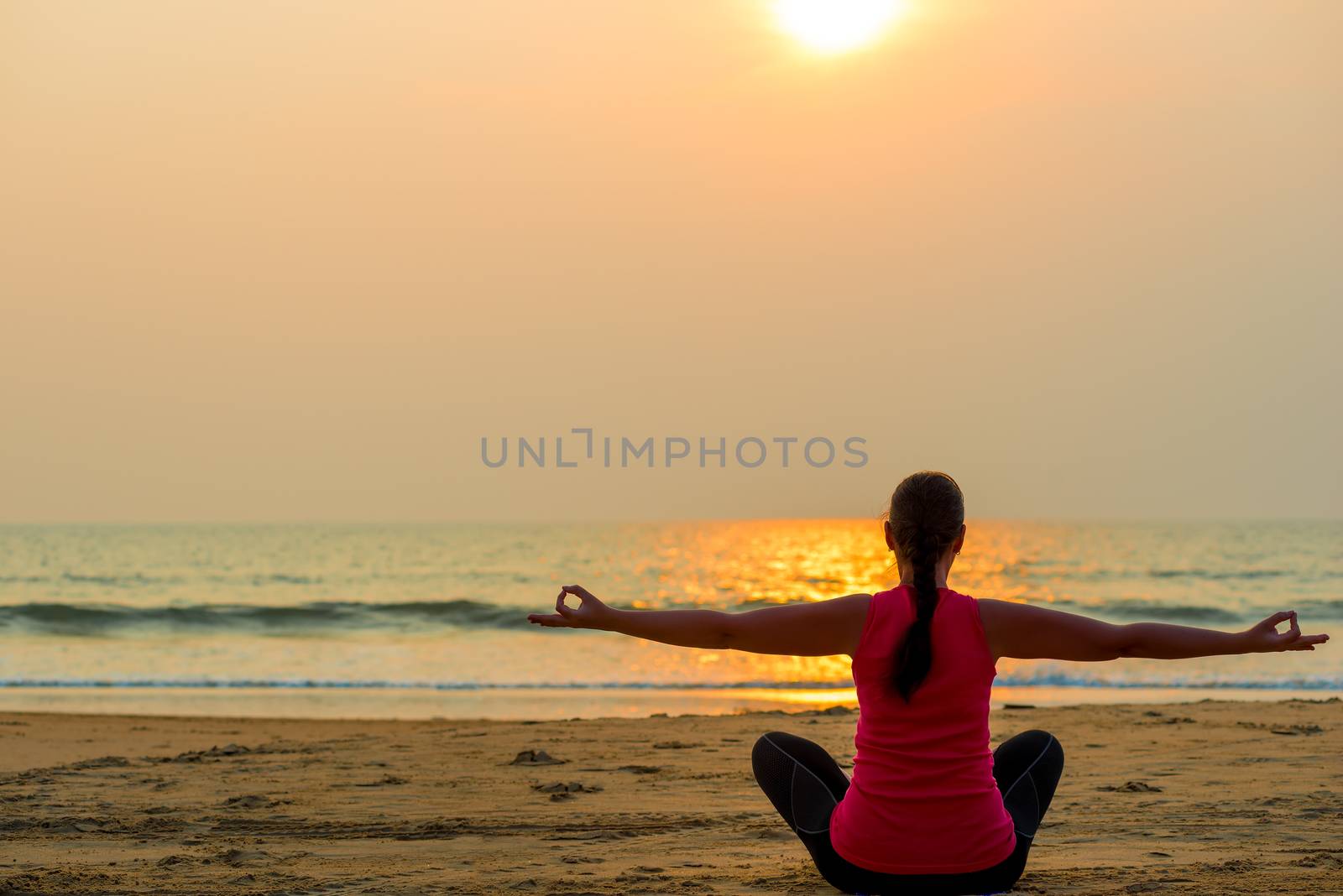 woman in the lotus position and setting sun