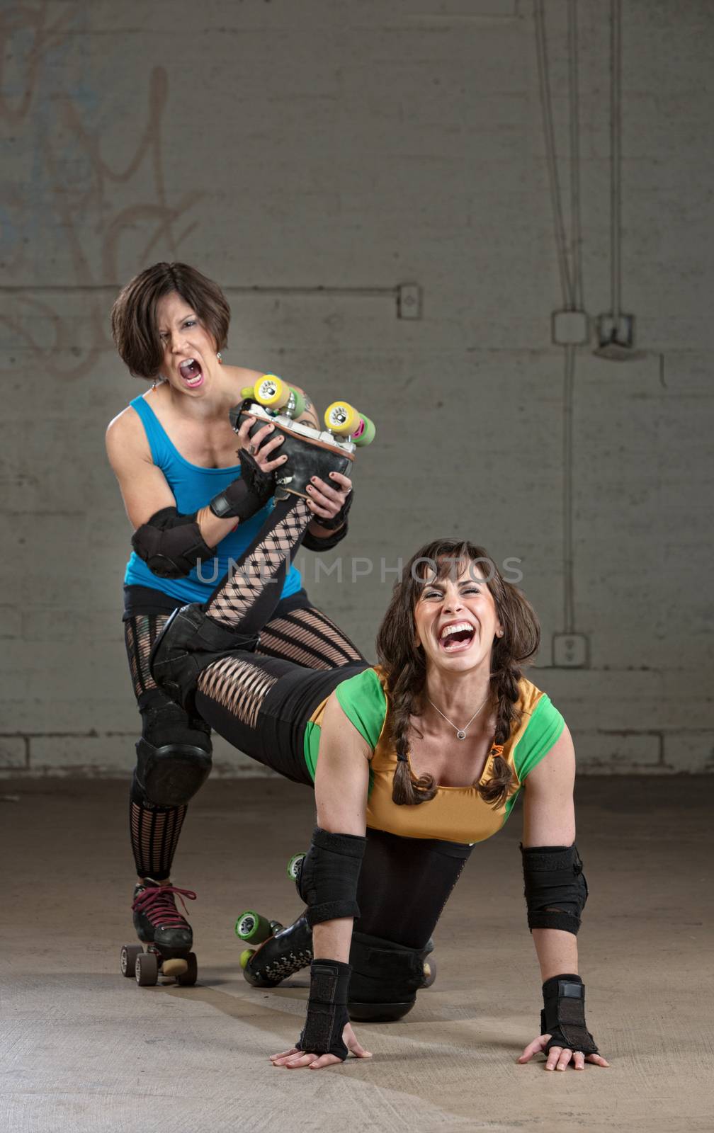 Bully roller derby skater twisting the leg of a woman