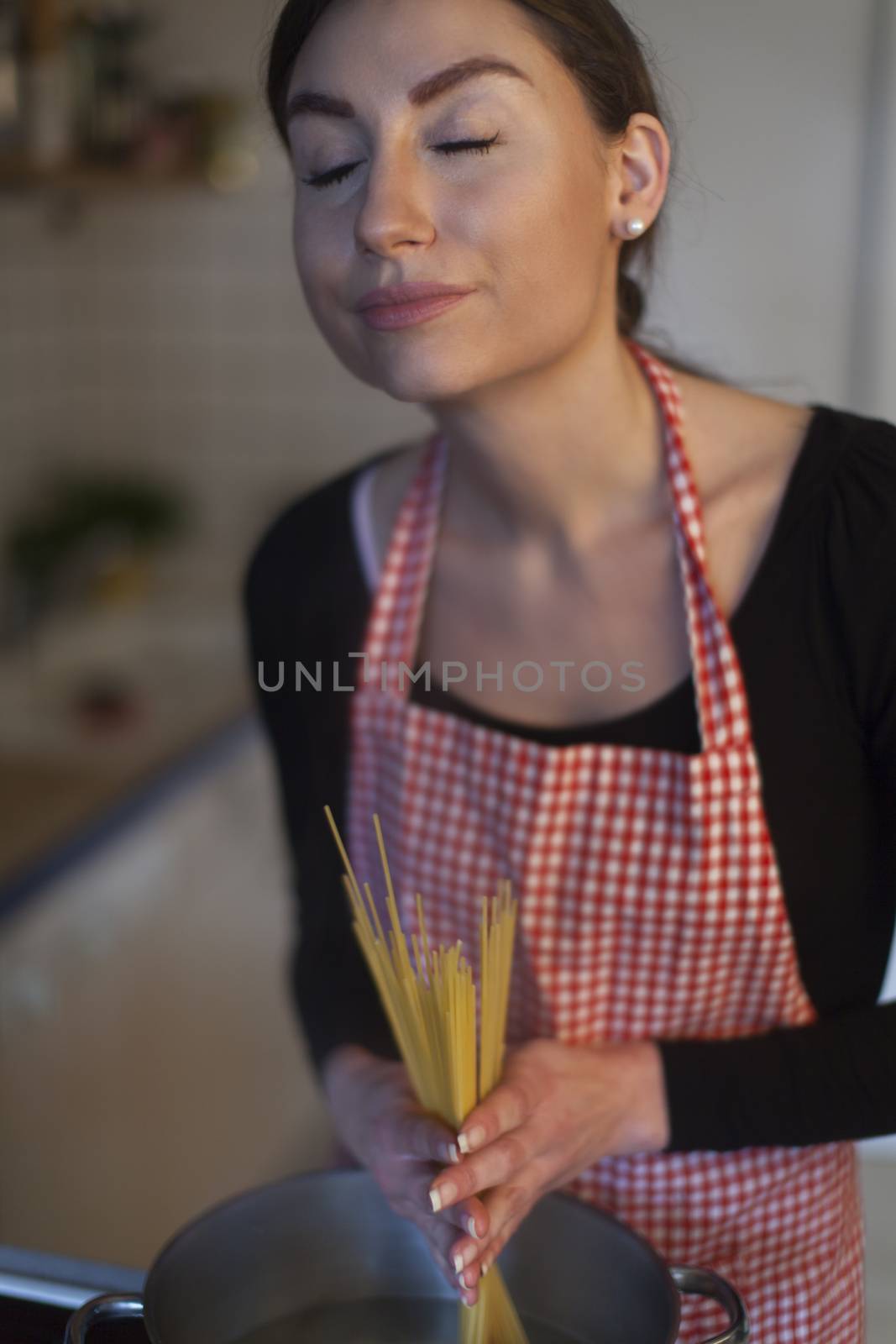 female cook making spaghetti by bernjuer