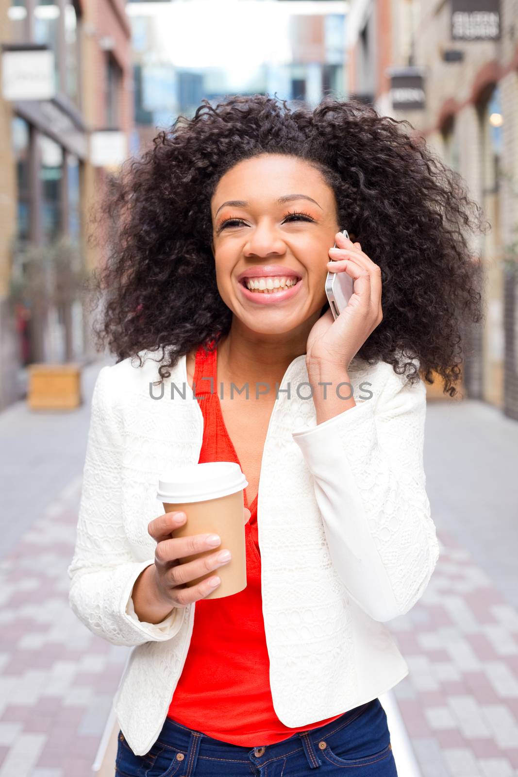 excited young woman talking on the phone with a coffee. 