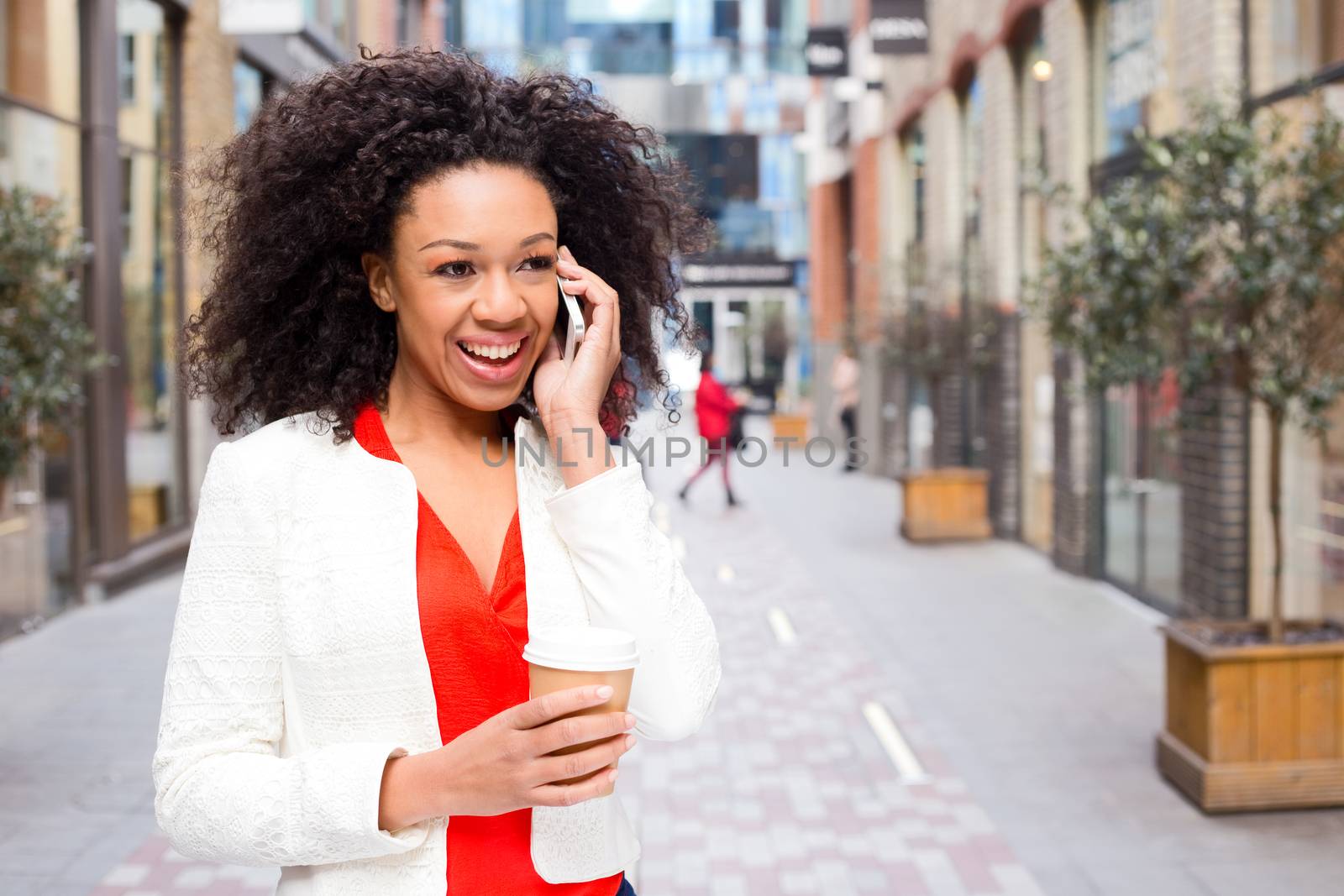 young woman talking on the phone with a coffee
