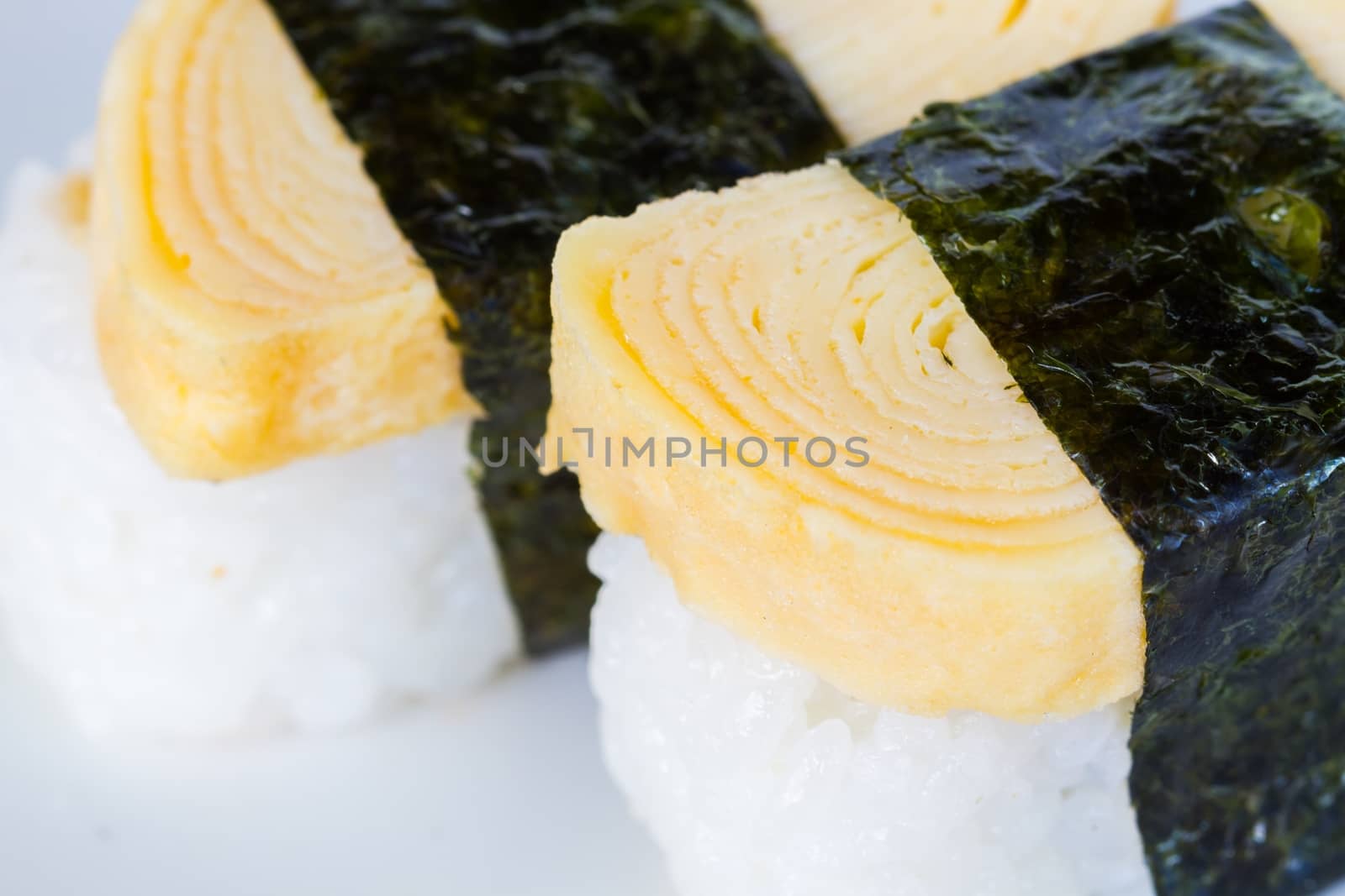 close-up tamako egg sushi, focusing on the roll egg