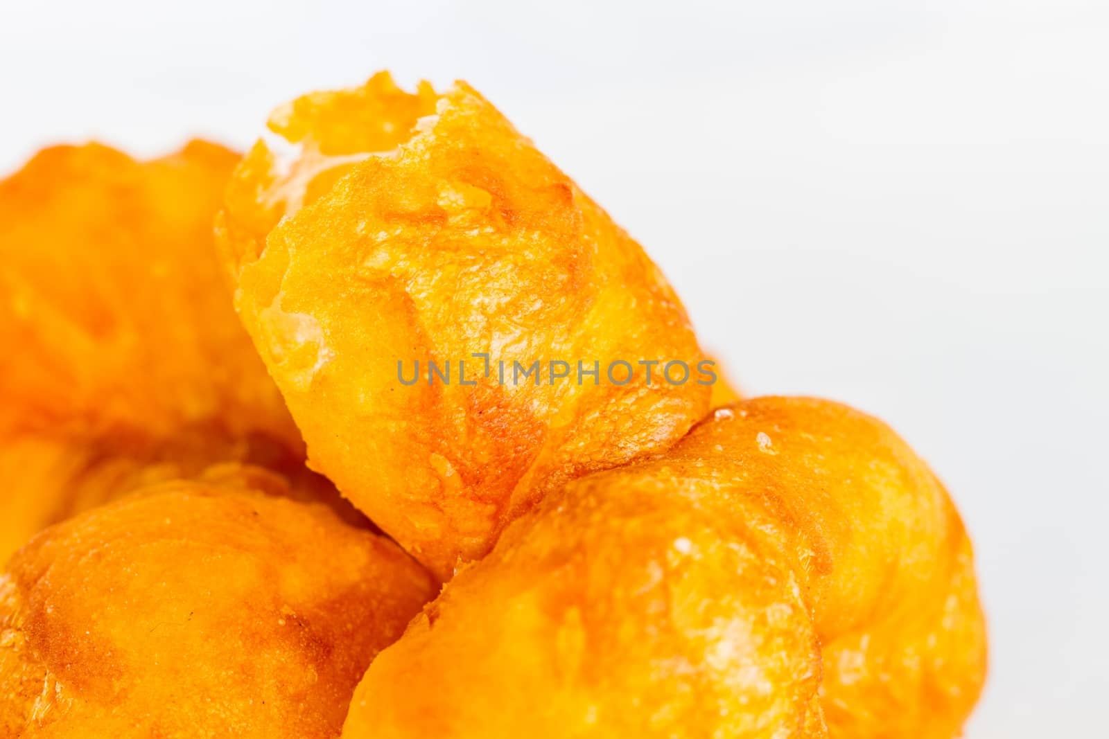extreme close-up deep-fried doughstick isolated on white background, soft focus
