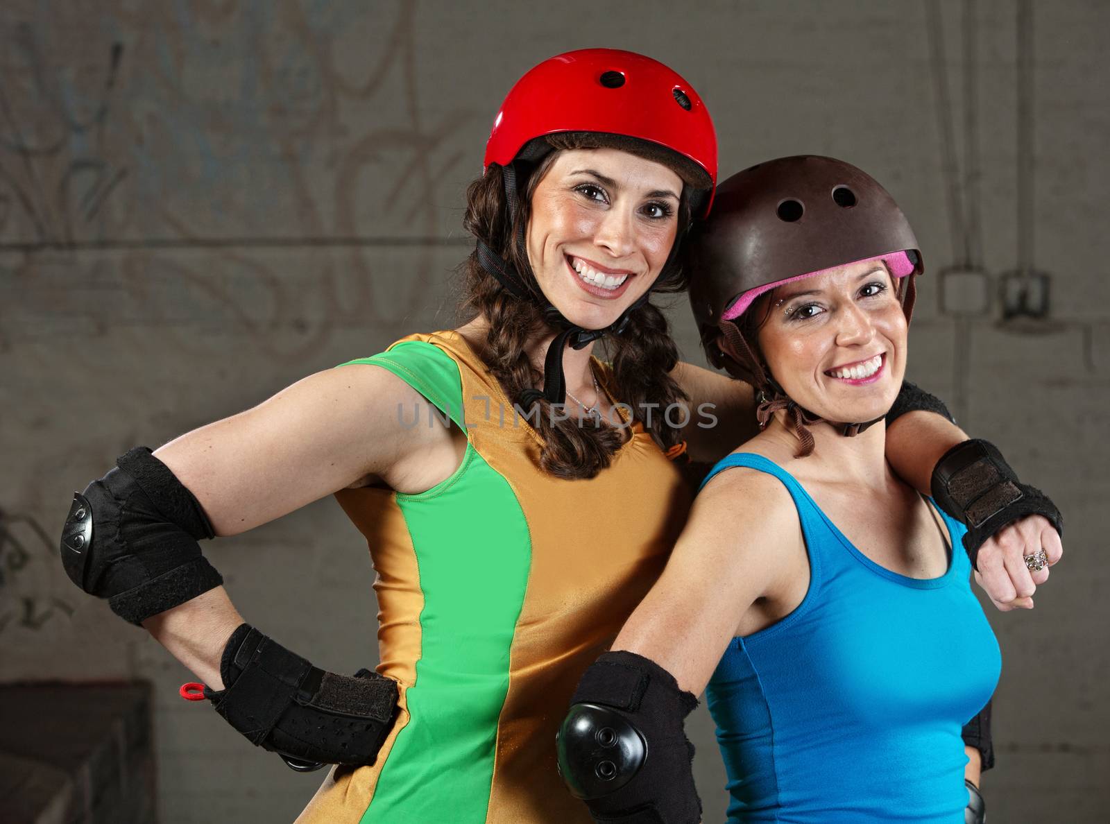 Pair of happy adult roller derby friends