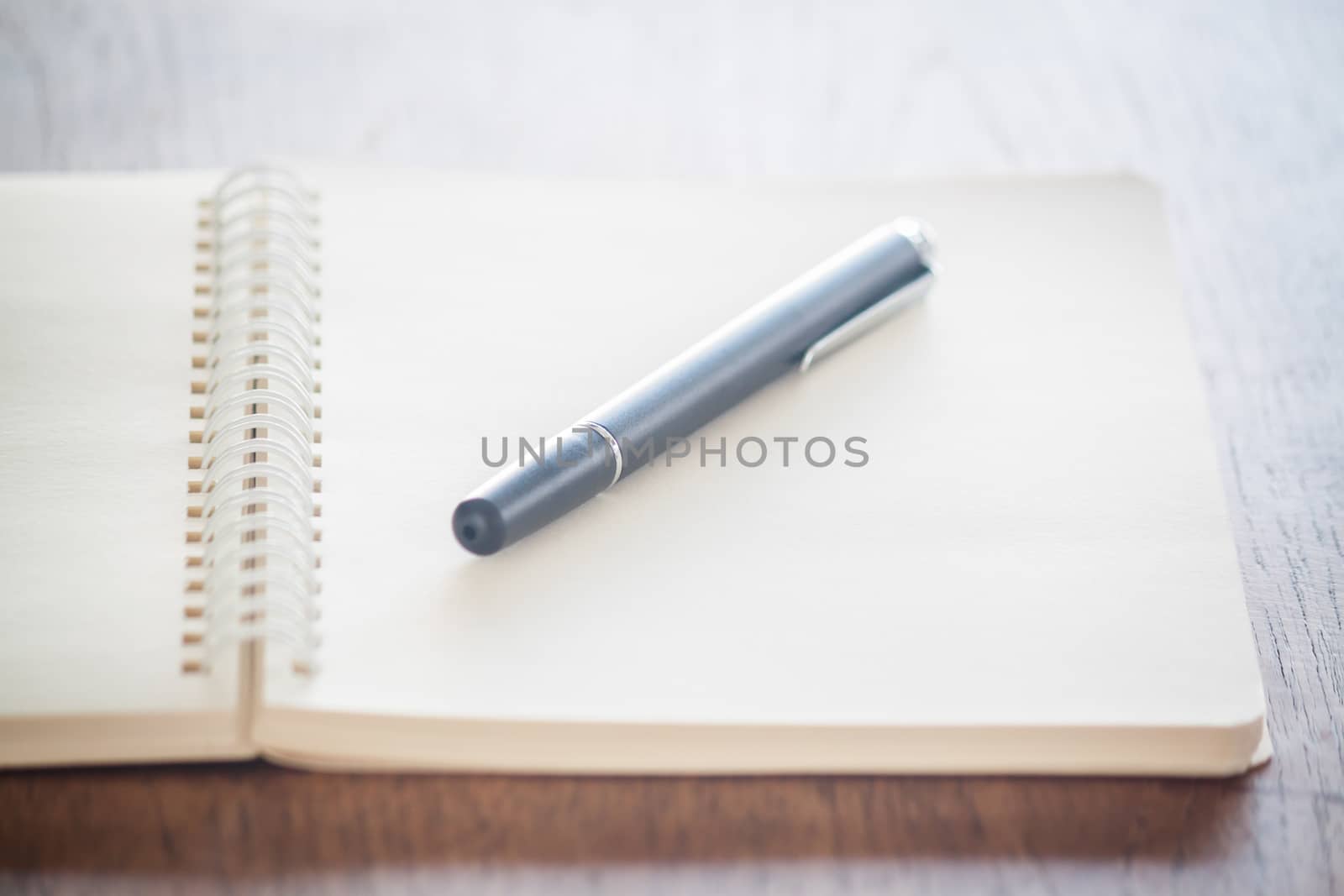 Blank notebook with pen on wooden table, stock photo