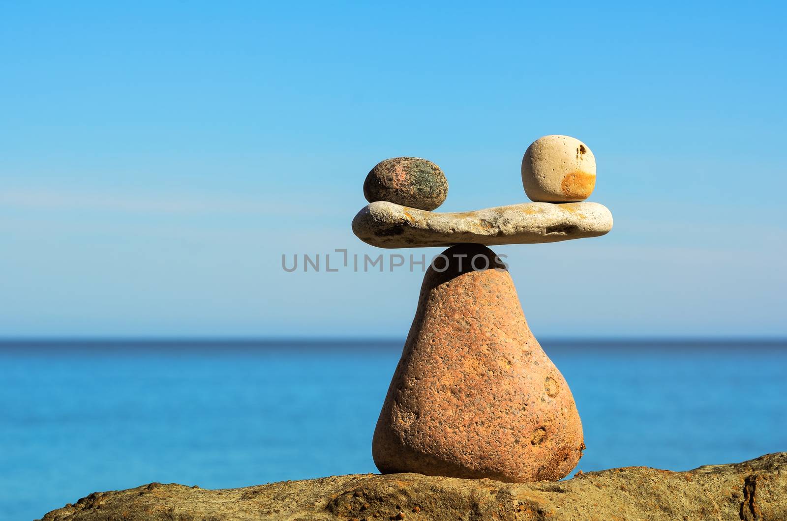 Symbol of scales is made of pebbles on the sea boulder