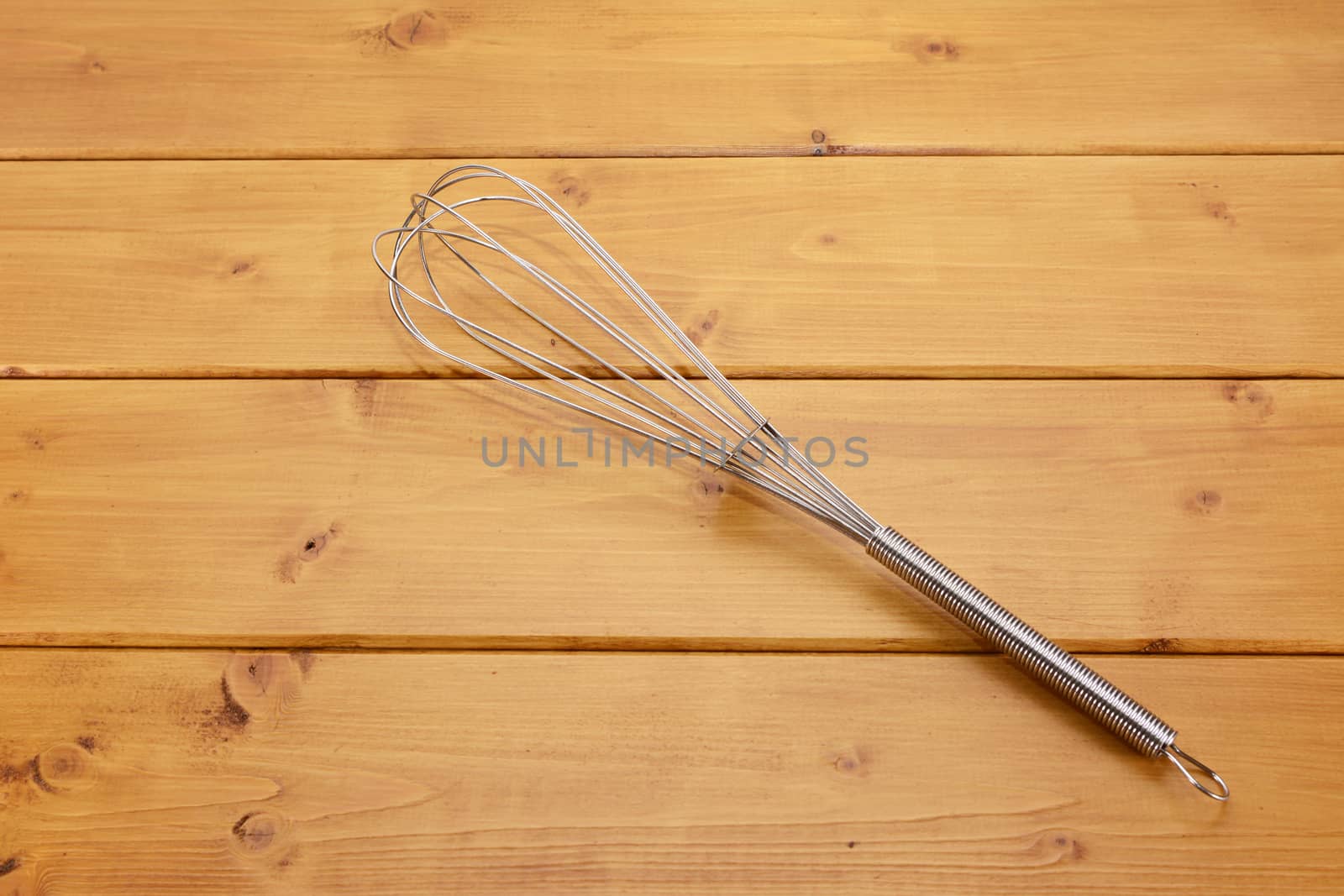 Metal balloon whisk on a wooden table