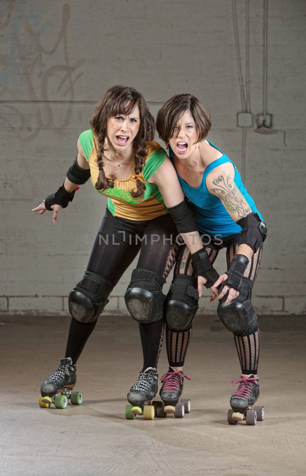 Aggressive women roller derby skaters threatening with a pose