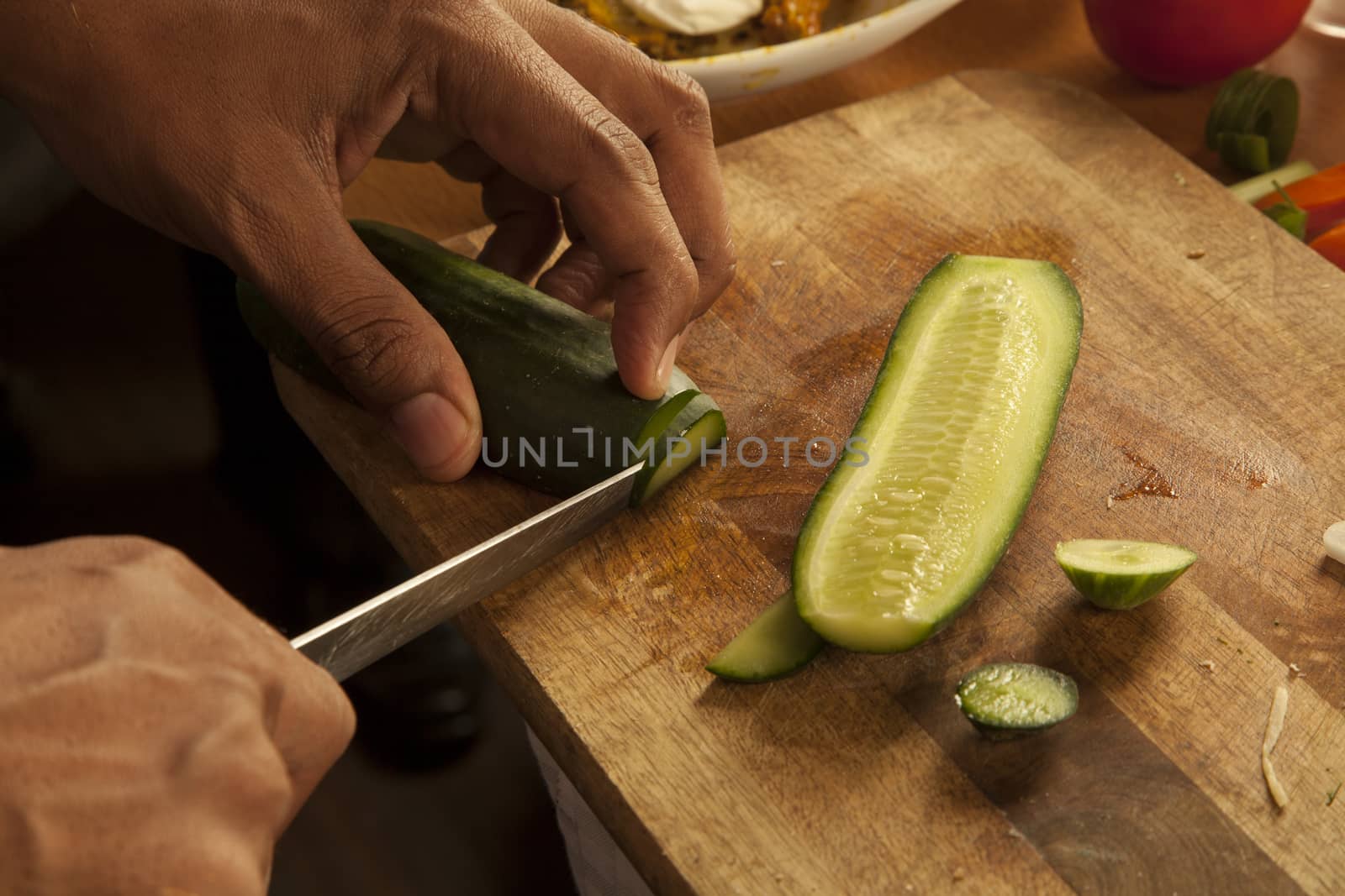 Chef chopping cucumbers on a chopping board