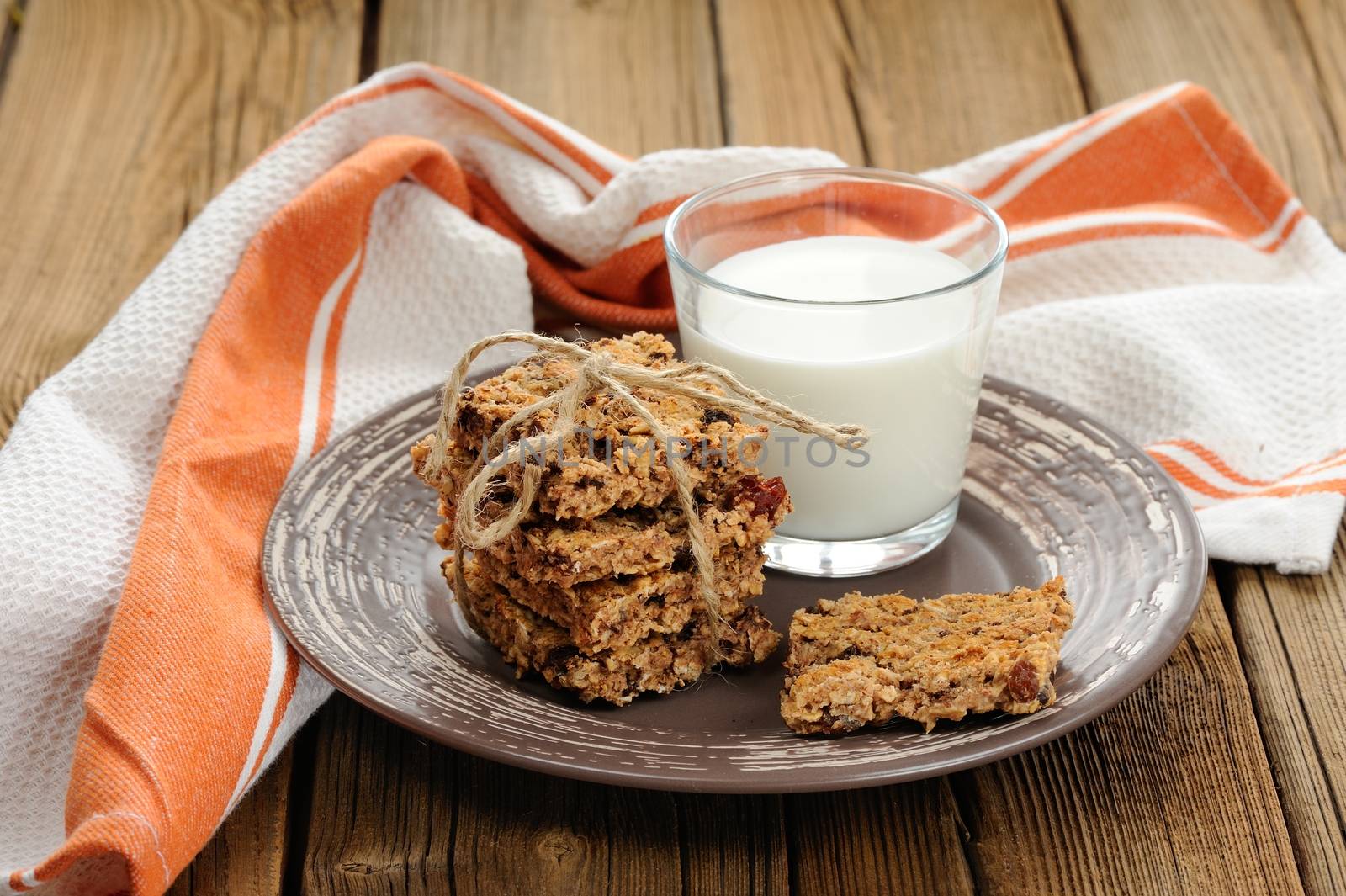 Granola bars with glass of milk on wooden background horizontal