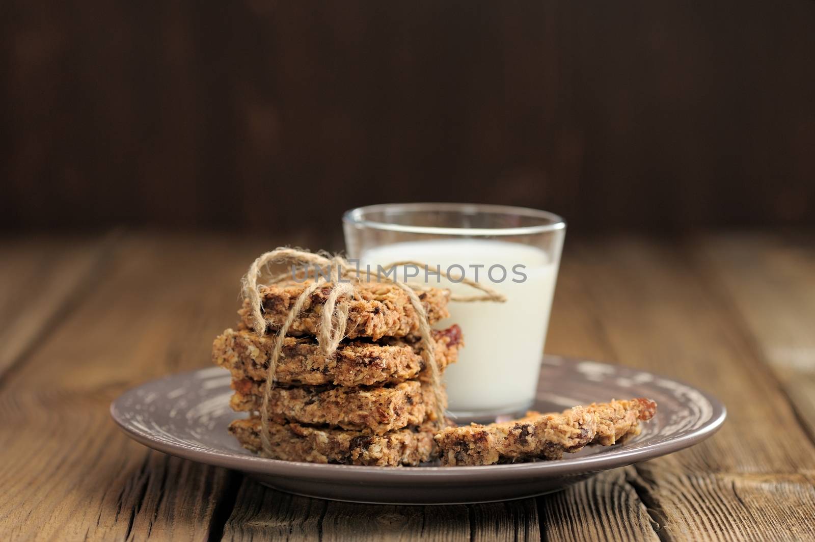 Granola bars with glass of milk on wooden background horizontal