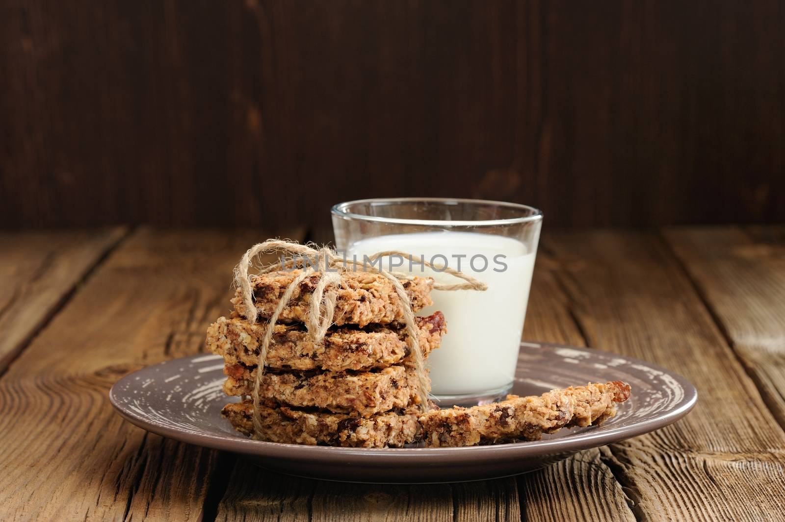 Granola bars with glass of milk on wooden background horizontal