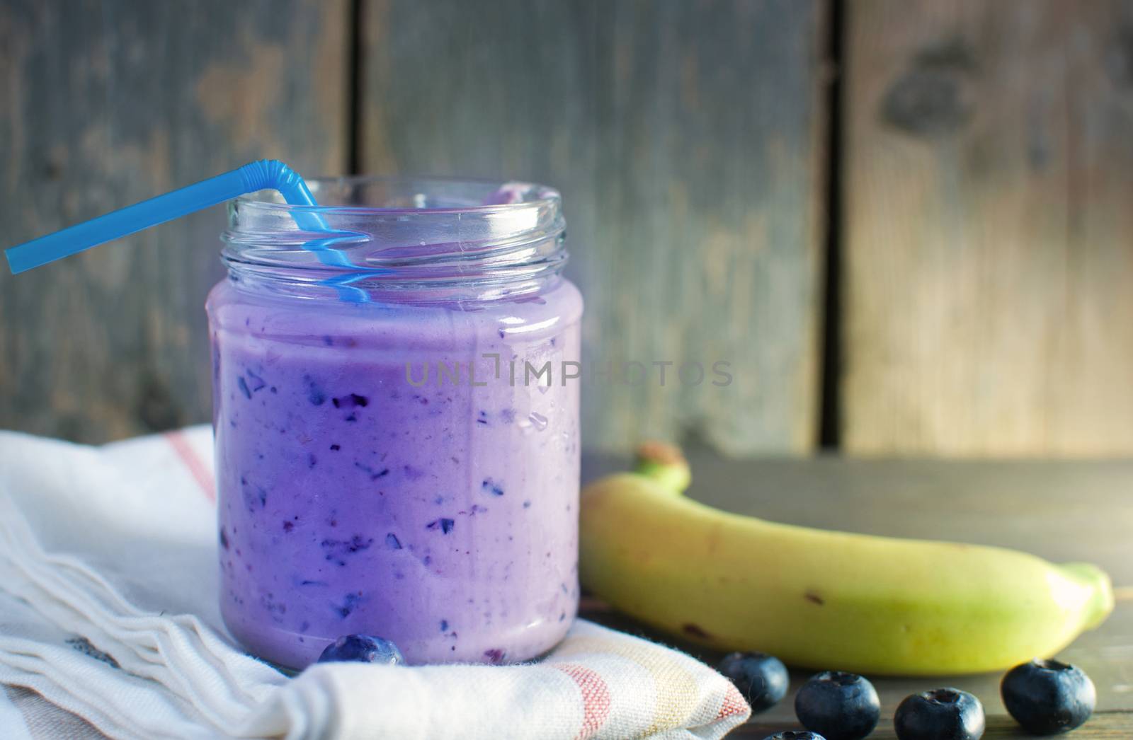 Blueberry flavored diet smoothie in a jar with a straw