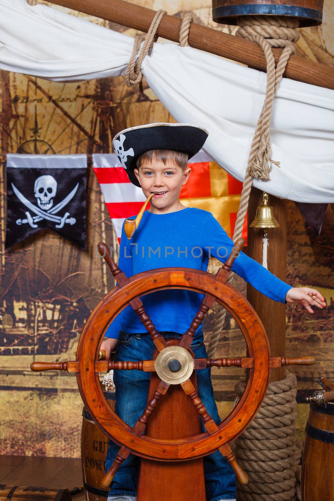 Cute little boy wearing pirate costume on the deck of a ship