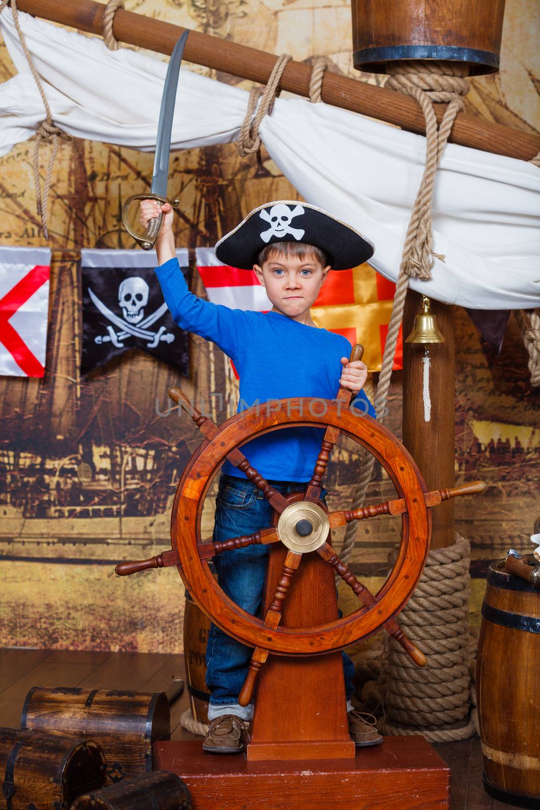 Cute little boy wearing pirate costume on the deck of a ship