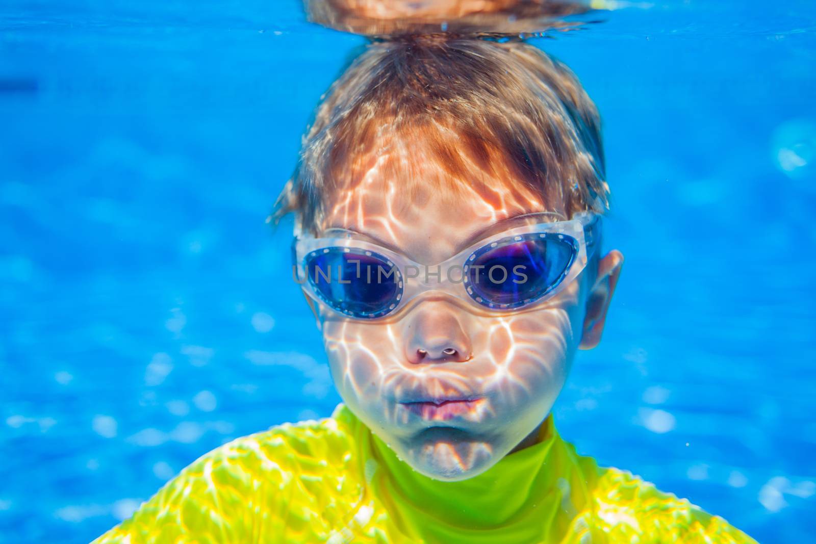 Closeup portrait of Underwater happy little boy in swimming pool