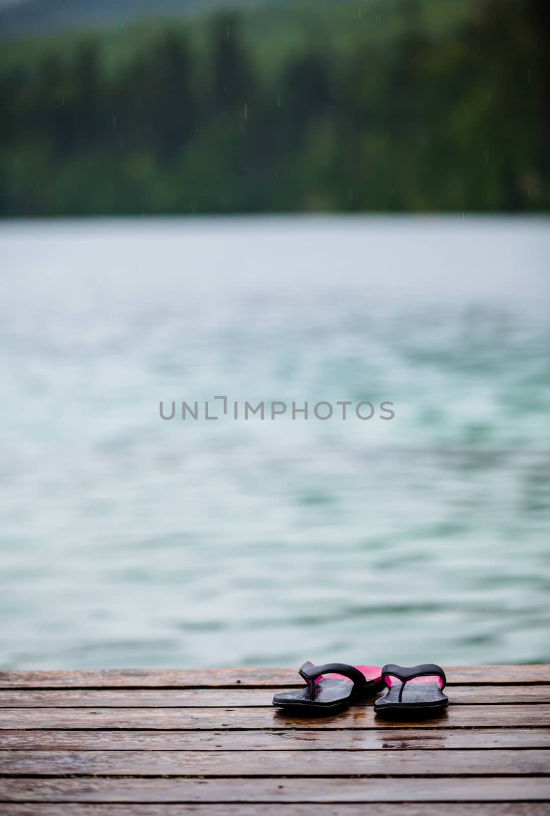 Flip flops on a Dock in front of a Turquoise Water Lake by aetb