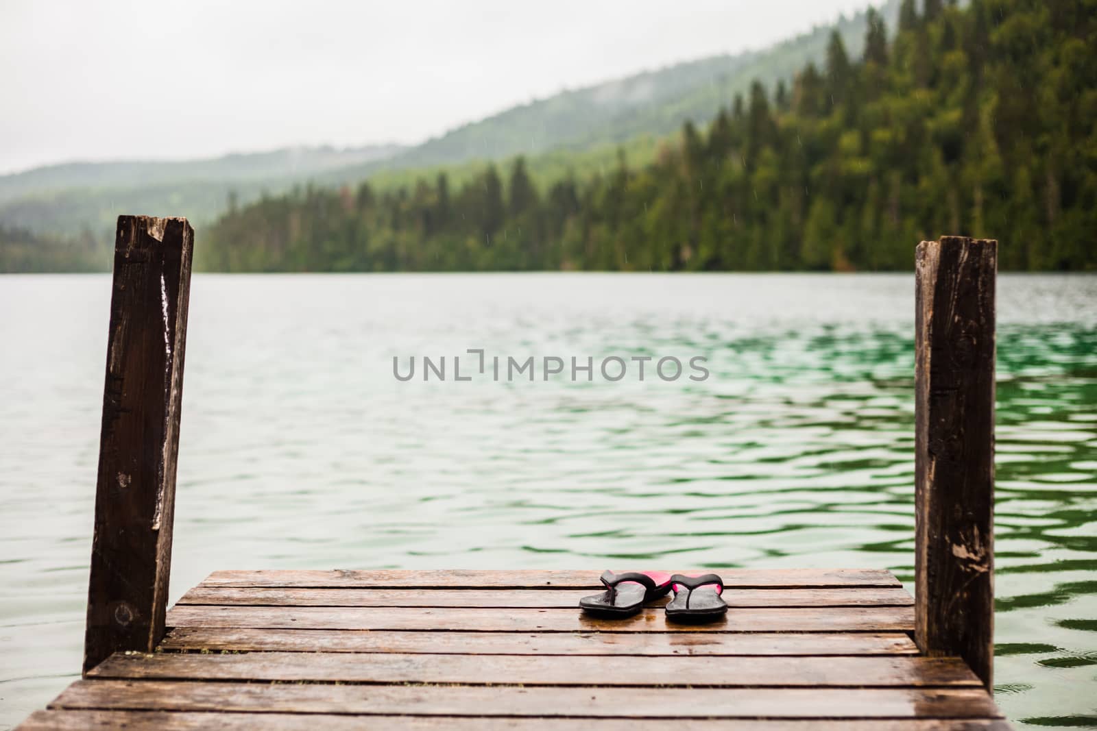 Flip flops on a Dock in front of a Turquoise Water Lake by aetb