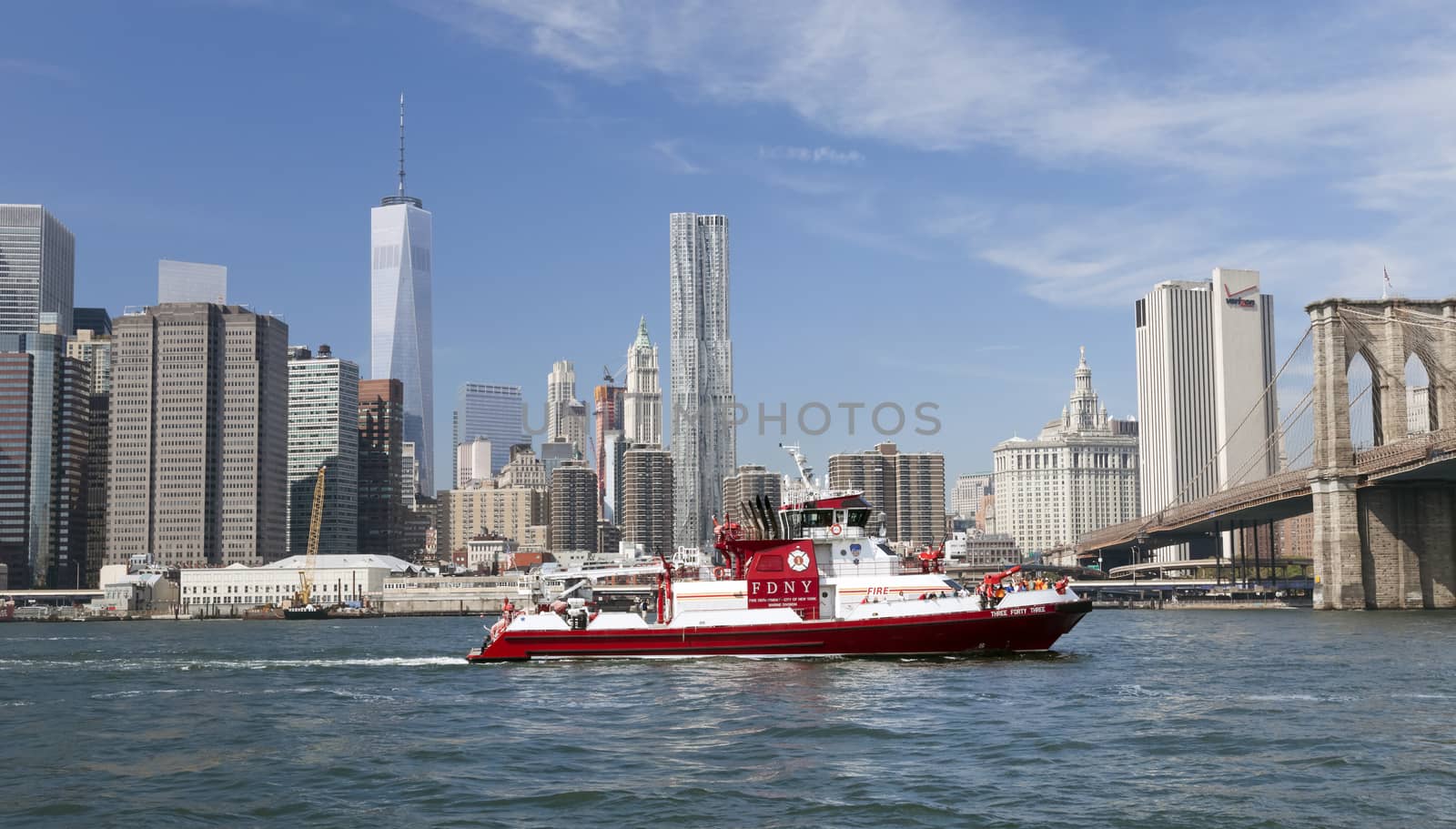 New York, USA - September 28, 2014: The fire boat No.343 on East River at lower Manhattan. Named in honor of the 343 FDNY members killed on Sept. 11, 2001, and with steel on the bow and stern from the World Trade Center, the fireboat is the world`s largest.