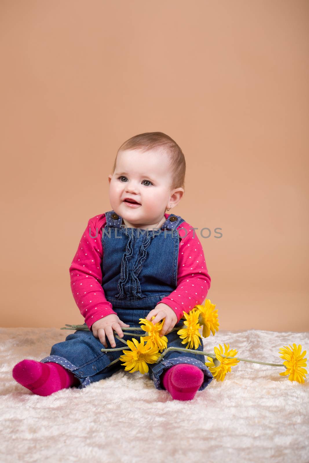 smiling infant baby with yellow flowers - the first year of the new life
