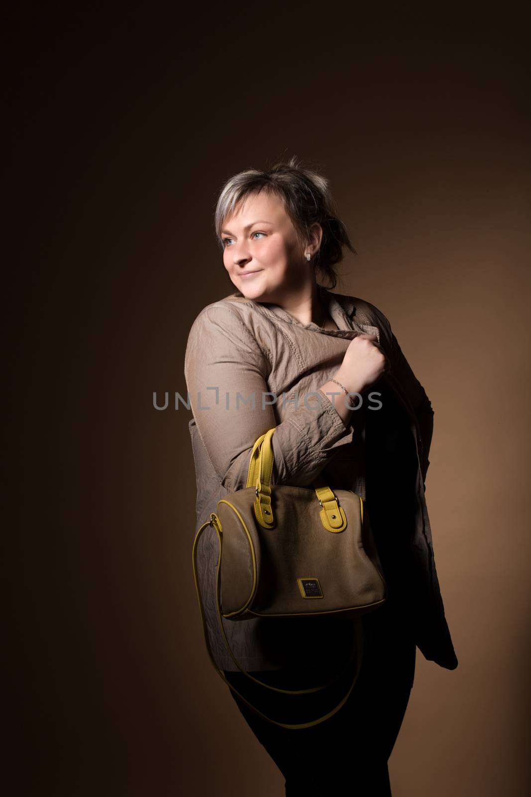 portrait of beautiful smiling plus size young blond woman posing with designer handbags