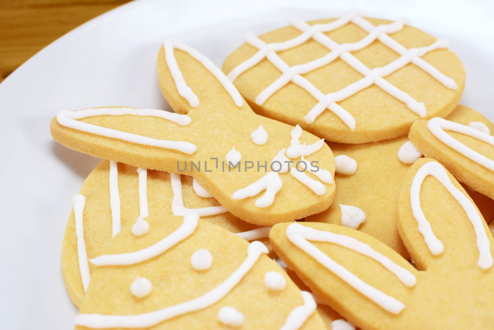 Close up of frosted Easter cookies on a plate - rabbit and egg shapes