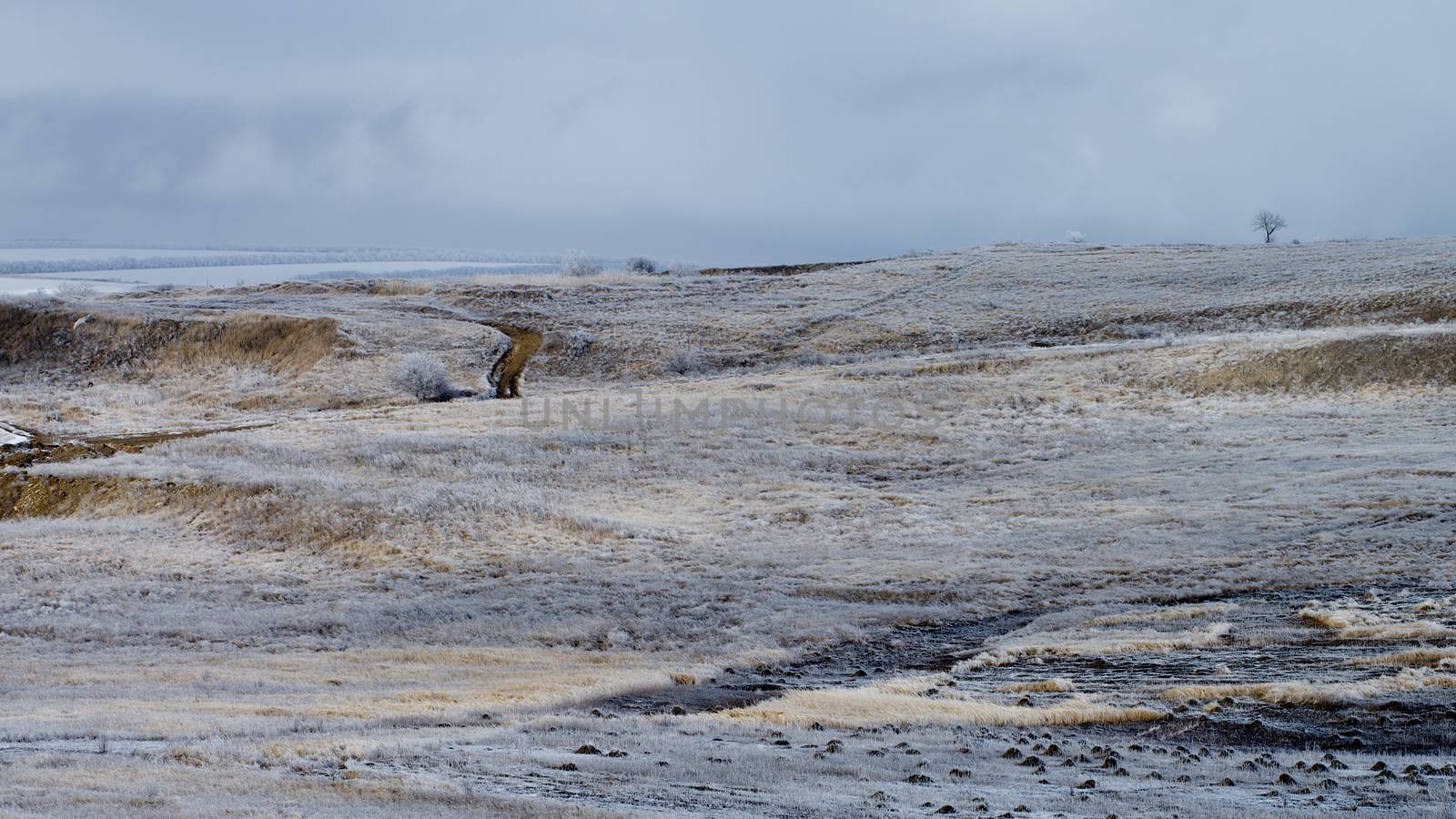 Rustic Road on Frosty Snowy Hills on Cloudy Sky background Outdoors