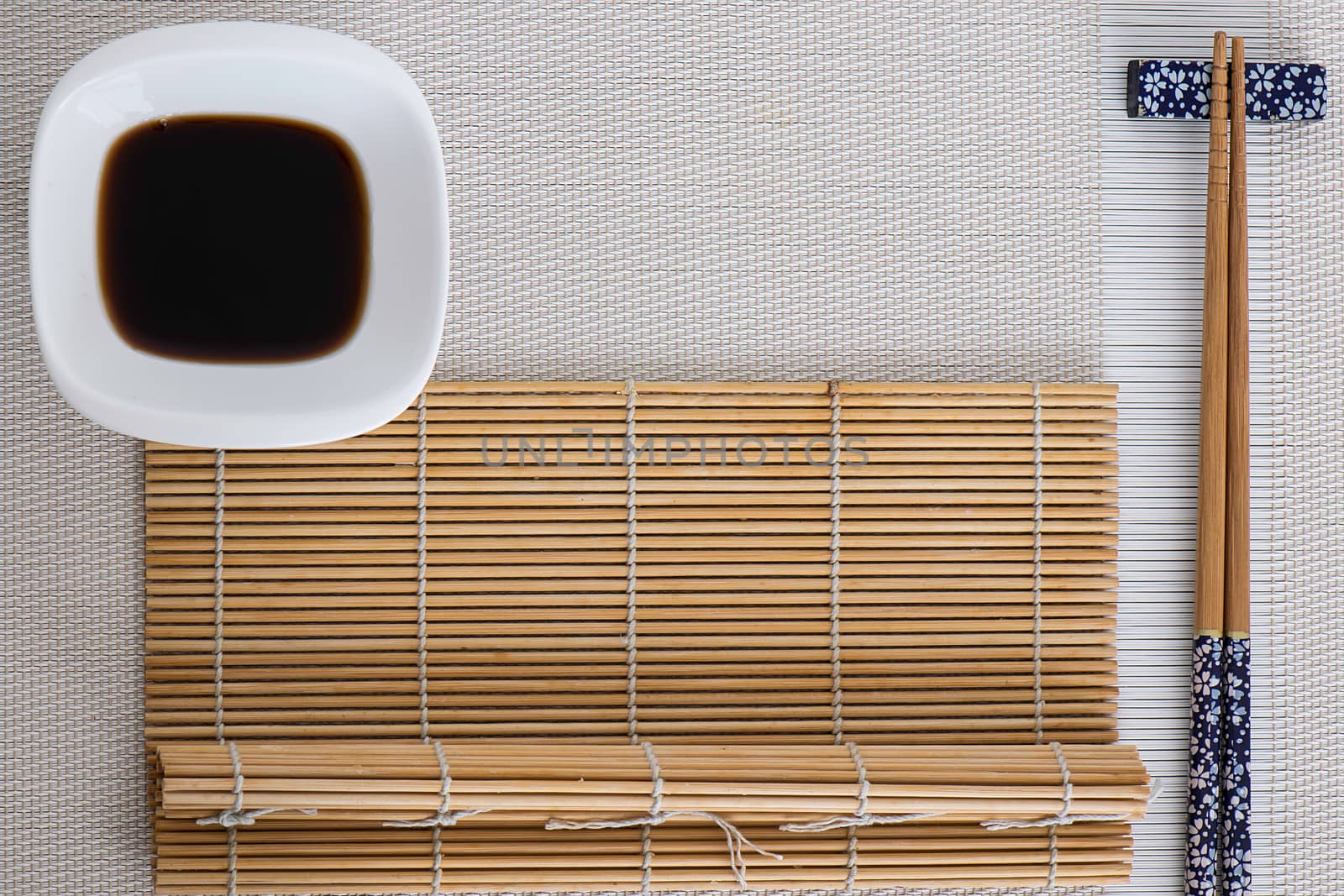 Some sushi tools set on white background and a bamboo mat