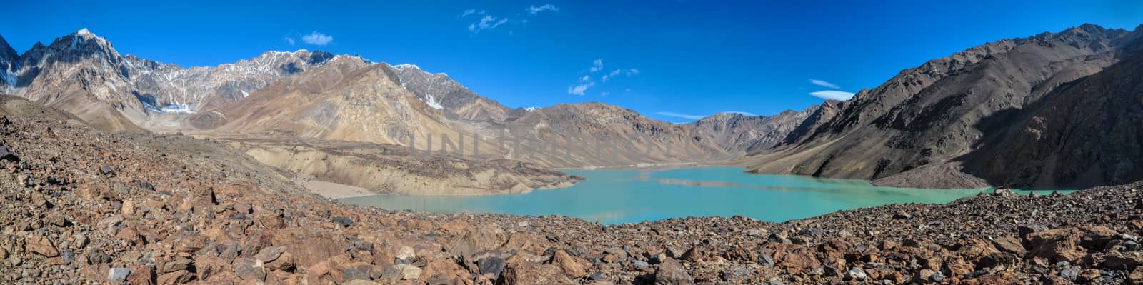 Scenic panorama of turquoise lake on arid landscape in Tajikistan on sunny day